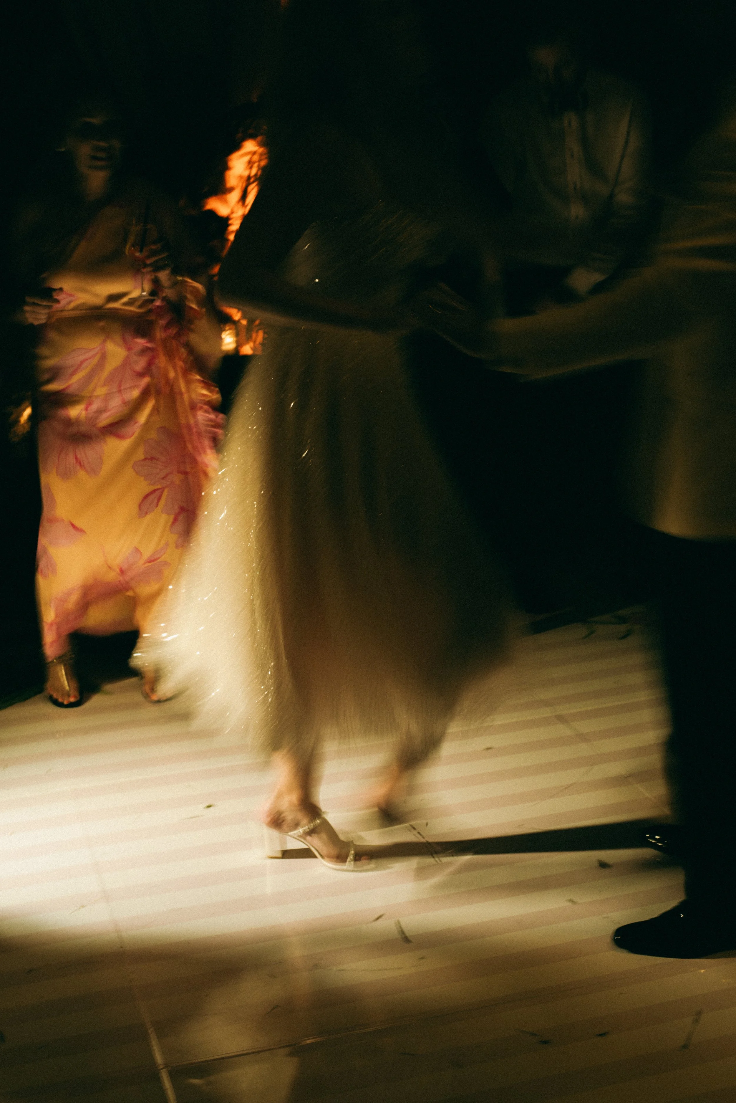 Motion-blurred photograph of Katie’s sparkling Milla Nova dress moving across the reception dance floor.