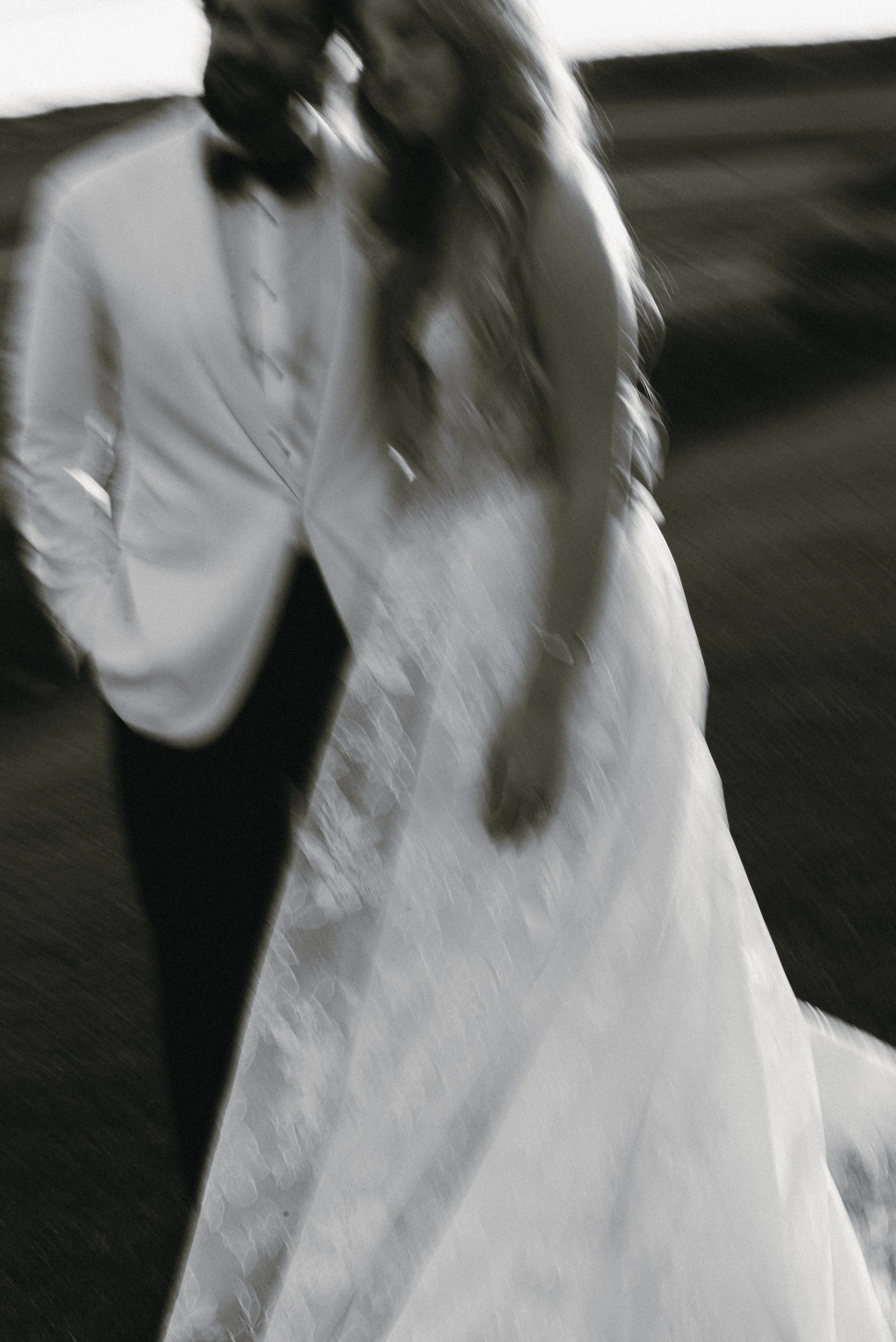 Soft-focus black-and-white portrait of Katie and Trevor moving together during their golden-hour session.