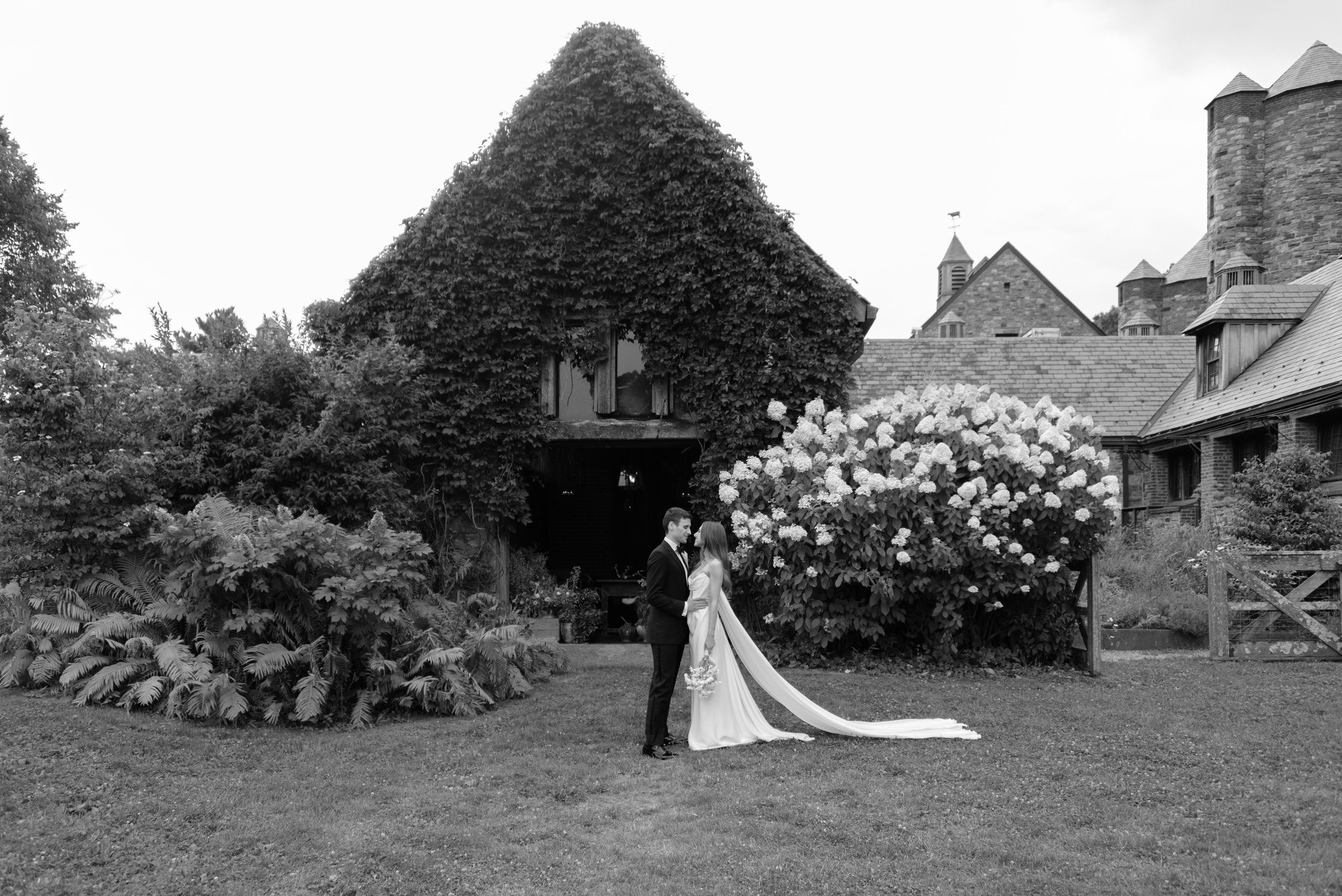Bride and groom framed by the long veil and historic landscape of their Blue Hill at Stone Barns wedding.