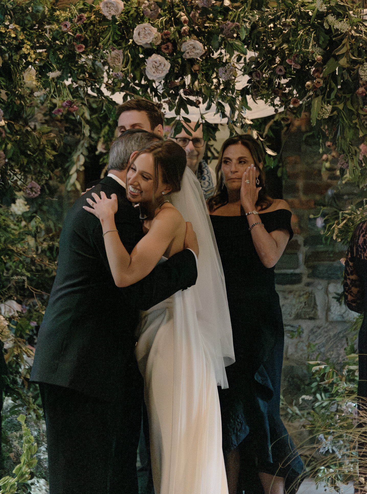 The bride hugs her father as her parents give her away at the chuppah. 