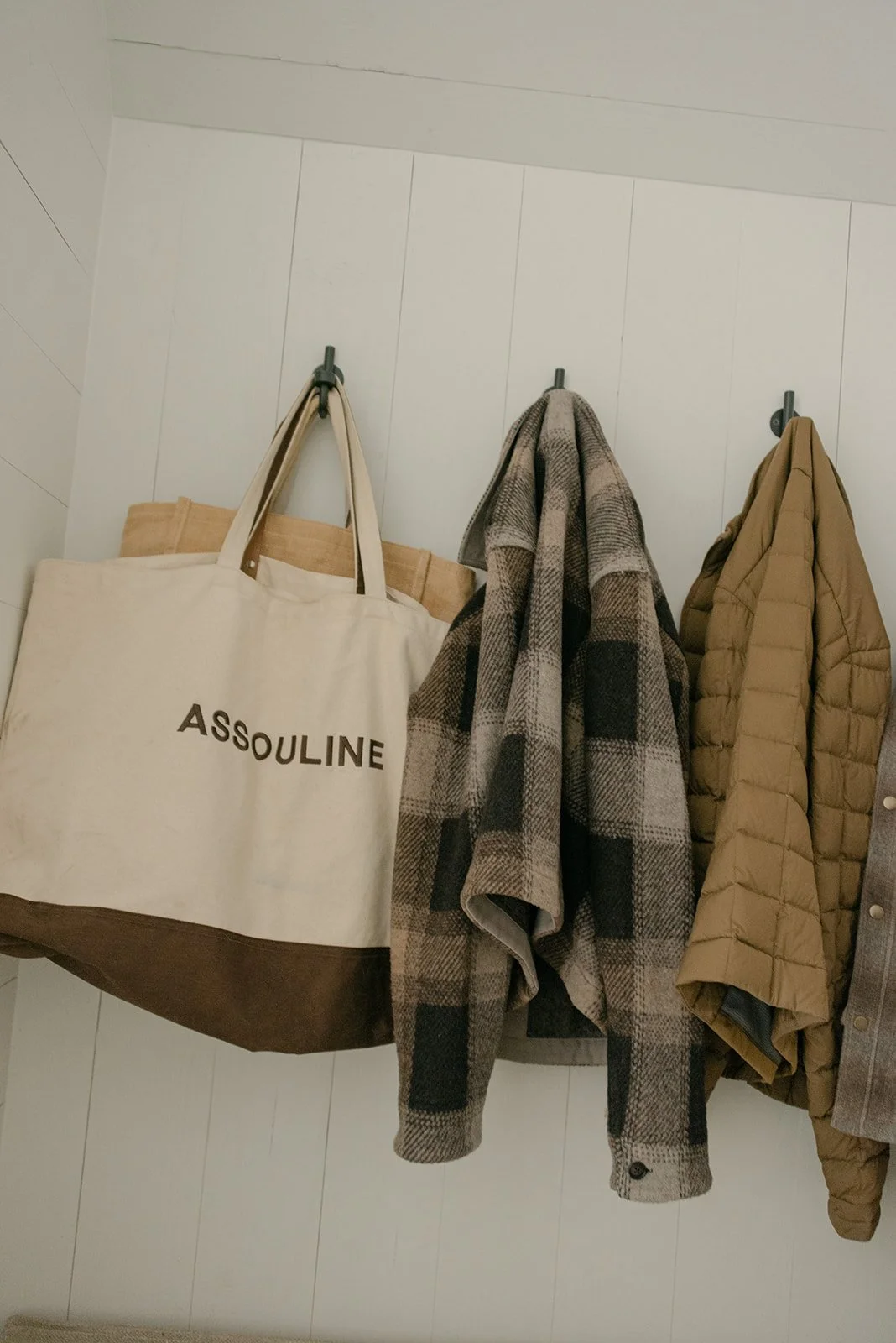 Editorial lifestyle photograph featuring an Assouline tote and textured garments, capturing the fashion-forward details and personal style surrounding a commercial event at Sardis. 