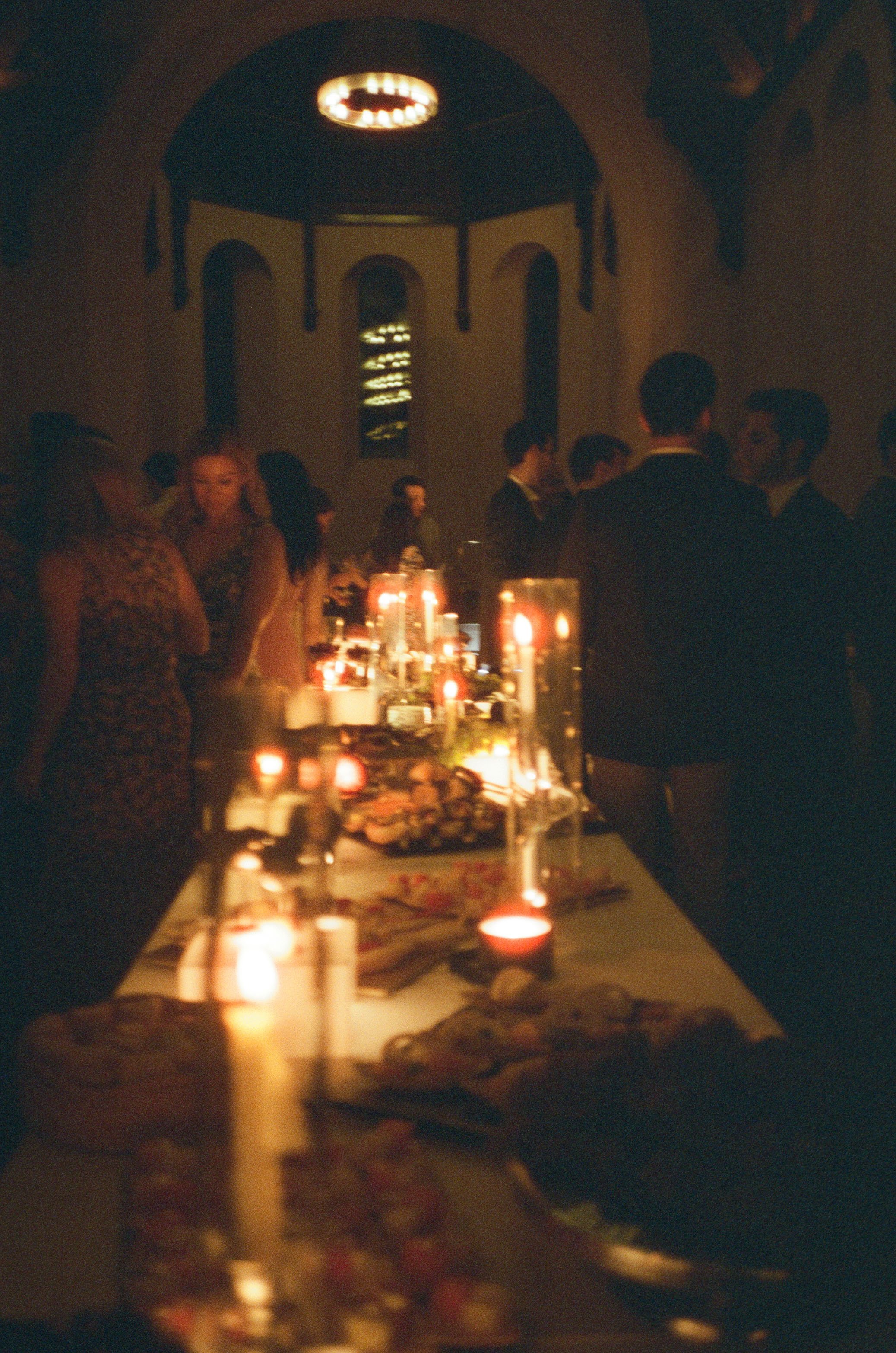 Candlelit rehearsal dinner table glowing inside the historic event space at The Abbey Inn & Spa captured on Cinestill 400d film.