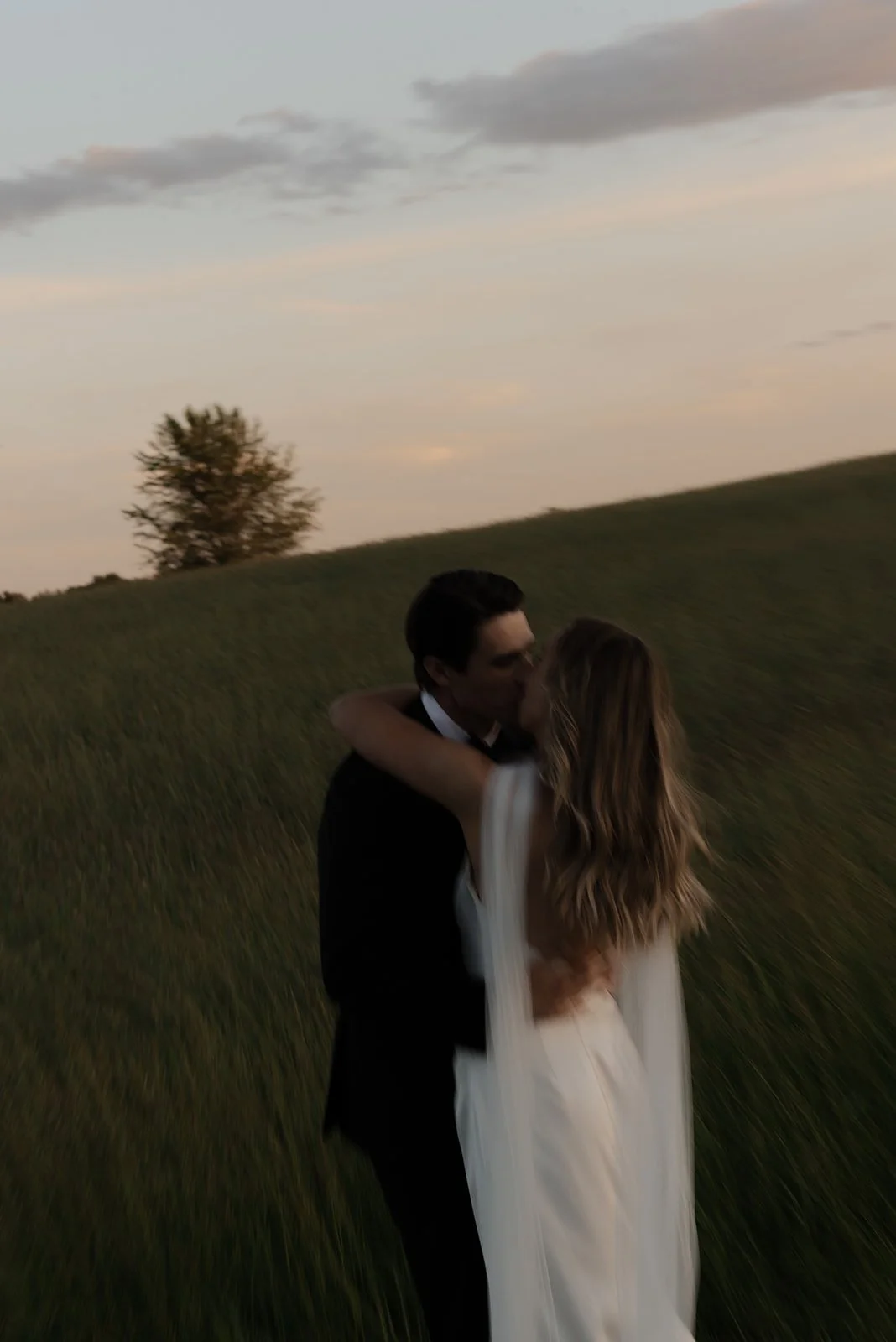 Motion-blurred wedding portrait of a bride and groom embracing in the Virginia countryside at Goodstone Inn.