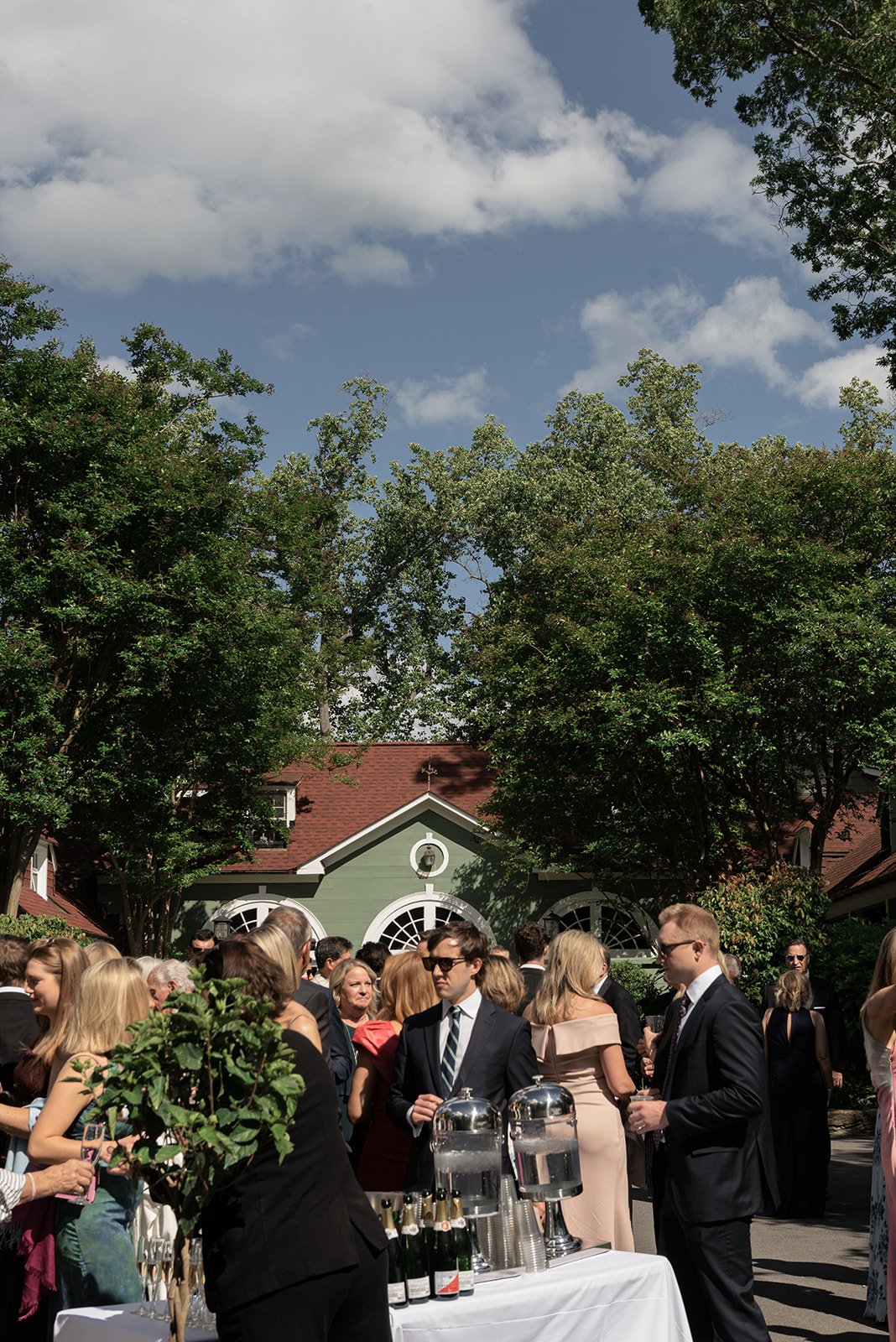 Wedding guests gathered outside beneath a bright blue spring sky at Goodstone Inn.