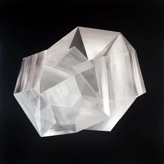 A clear, geometric, faceted crystal against a black background.