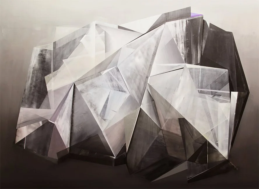 Abstract geometric sculpture with sharp angular facets in shades of gray, white, and black, mounted on a gray wall.