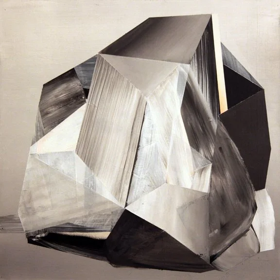 Abstract geometric sculpture made of painted wood or metal in black, white, and gray tones with sharp angles and faceted surfaces.