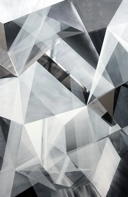 Close-up of a geometric abstract art design with overlapping translucent and reflective triangular shapes in shades of gray and black.