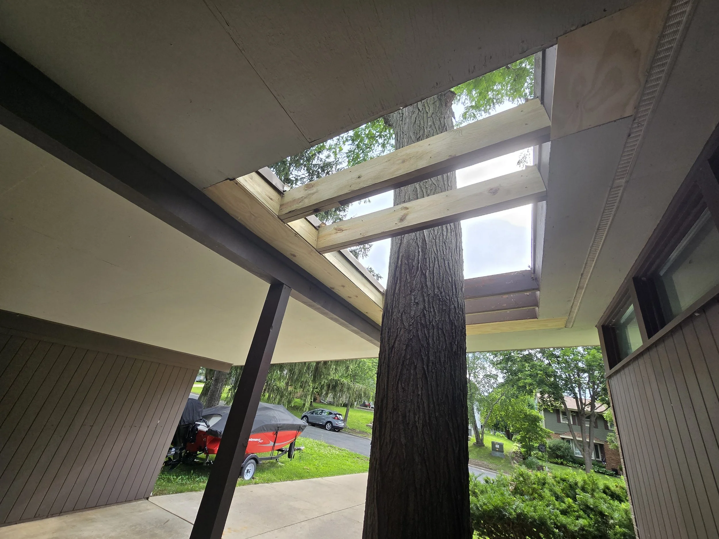 Repair severe rot in soffit and structural supports for a covered breezeway with a unique skylight for a tree!