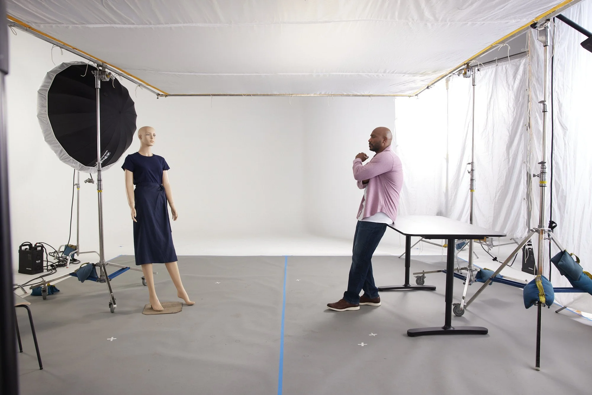 A man standing next to a mannequin
