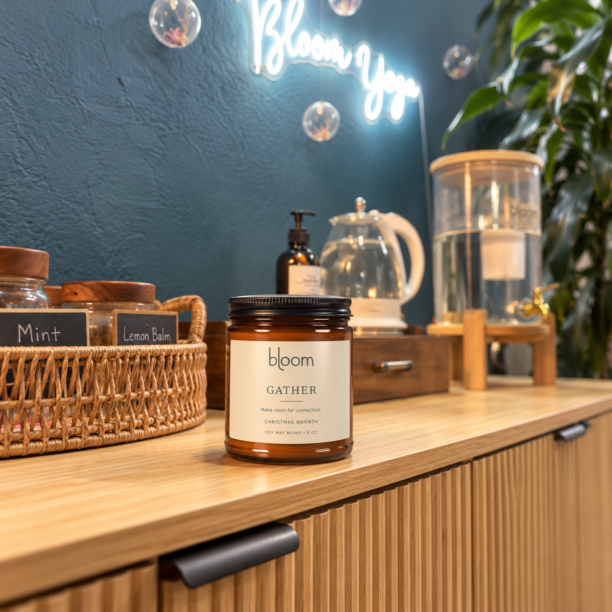 Bloom Gather 9 oz Christmas Warmth candle on the tea station at Bloom Yoga; styled product mockup.