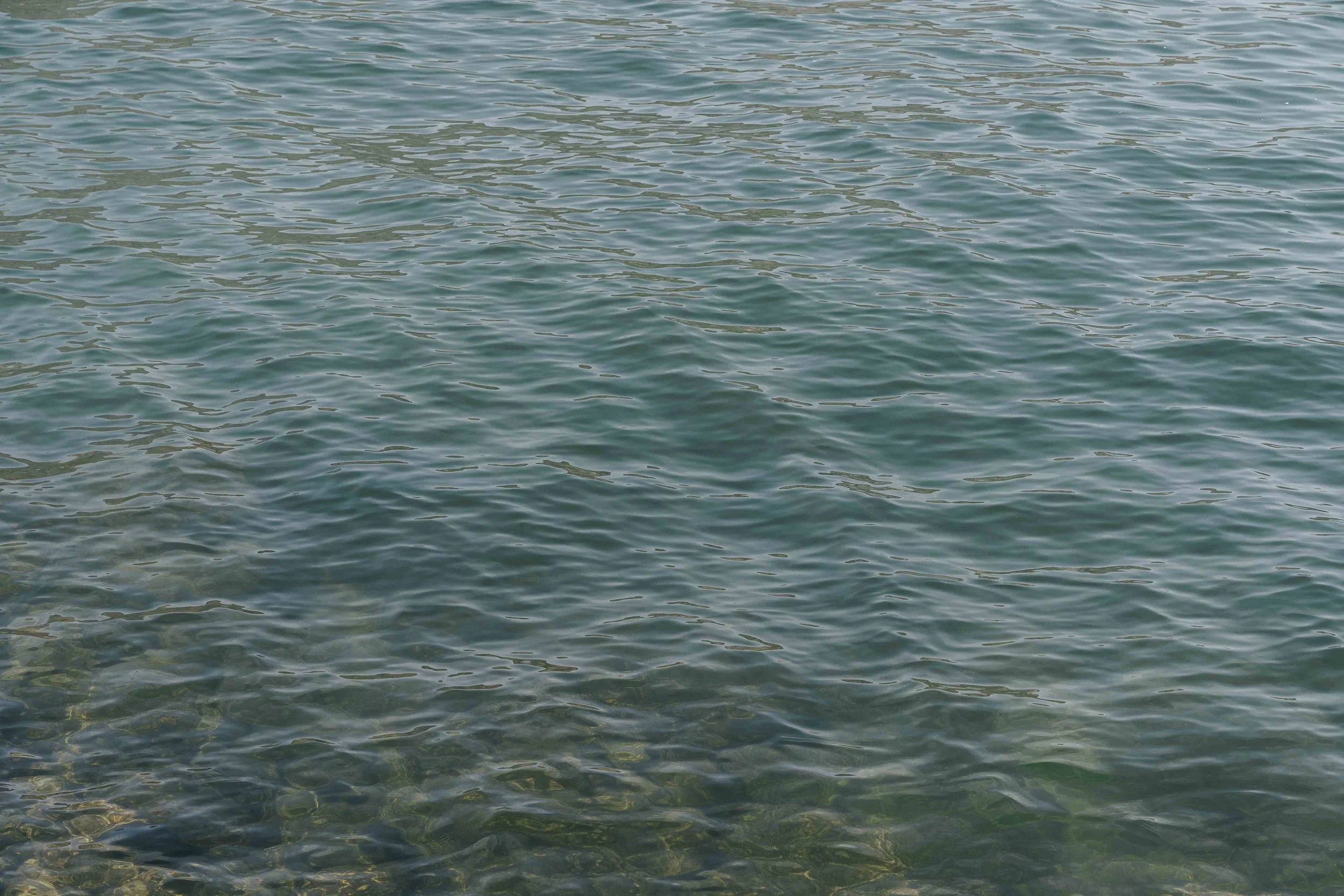 Blick auf das ruhige Wasser des Meeres oder Ozeans mit sanften Wellen.