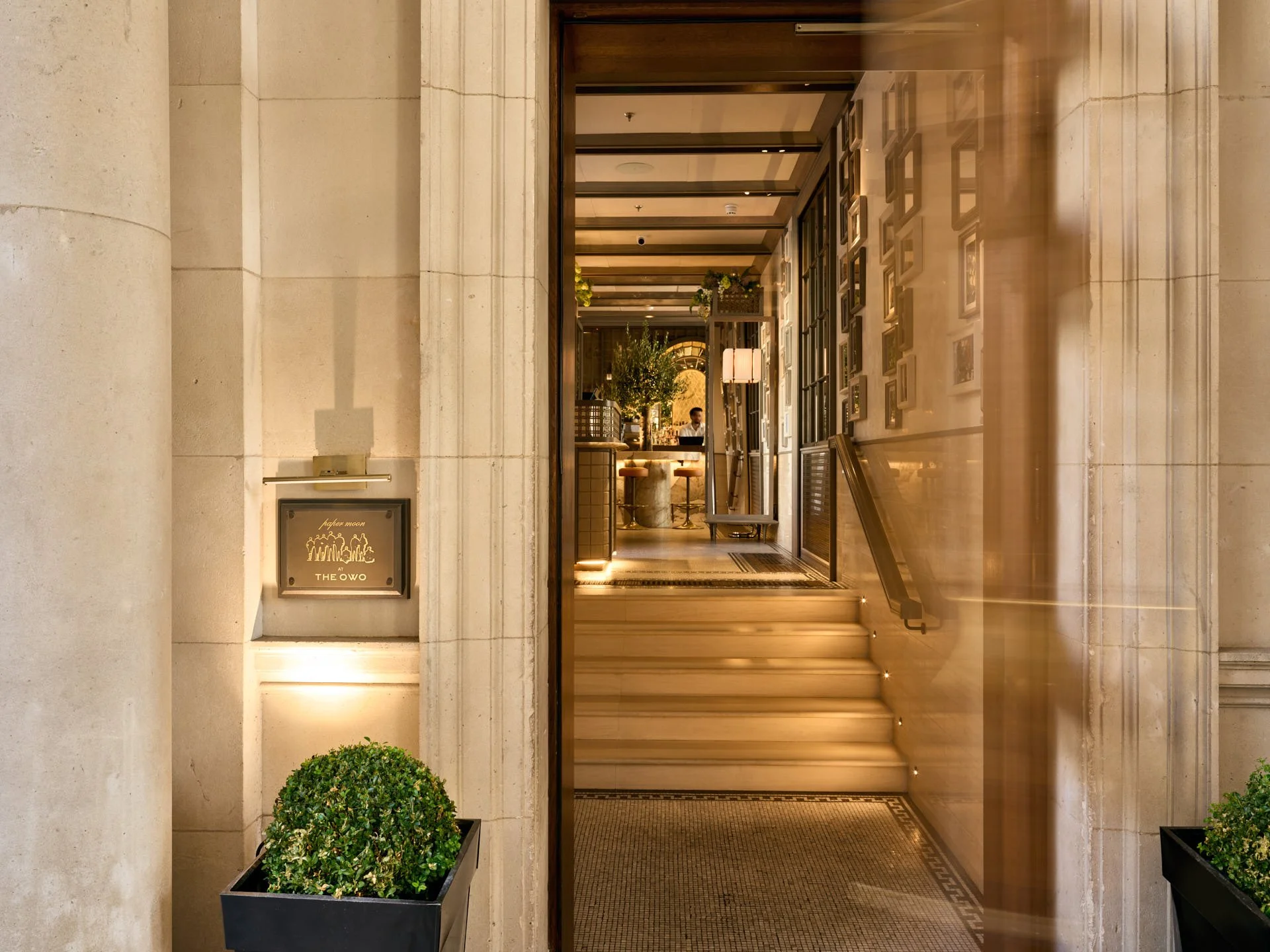 Entrance to Paper Moon at The OWO, with illuminated steps, restaurant sign and a view towards the bar.