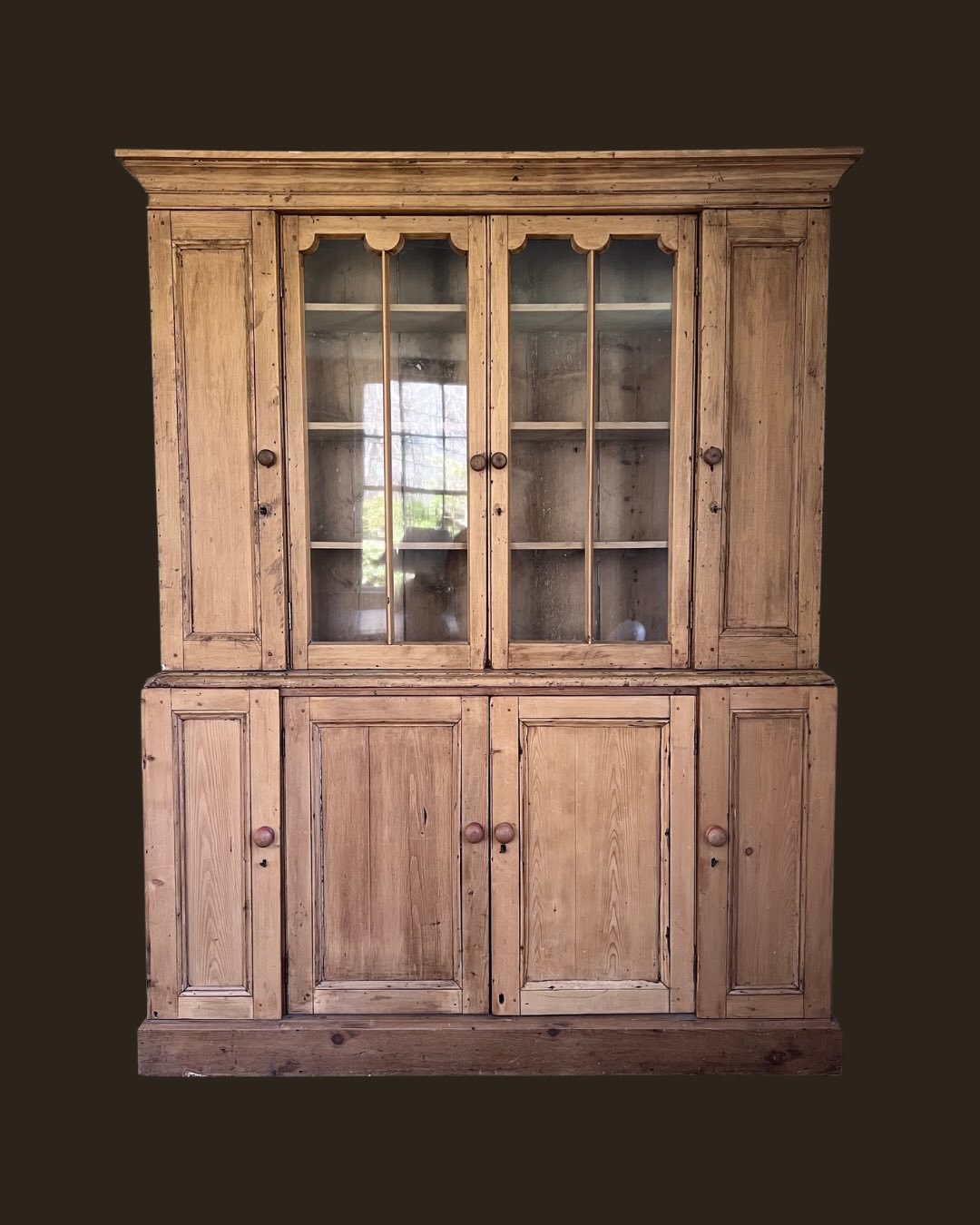 Spring 2026 Online Drop No. 12

This vintage english pine cabinet balances stately proportions with sweet, delicate details. Both the upper and base sections divide into three enclosed cabinets with interior shelving within each compartment, offering