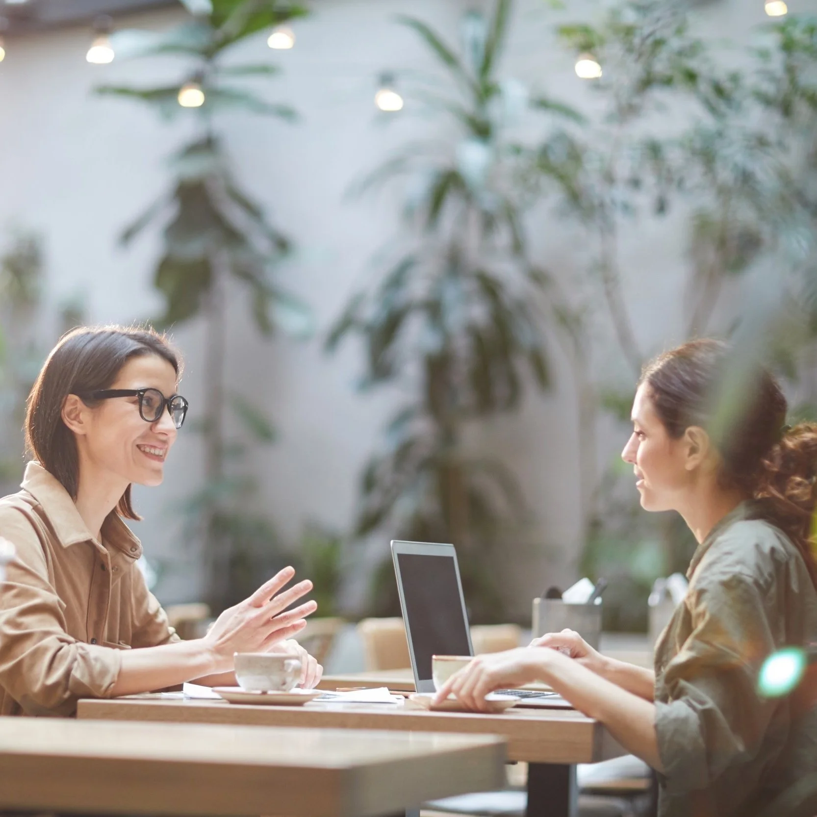 two women talking with laptop