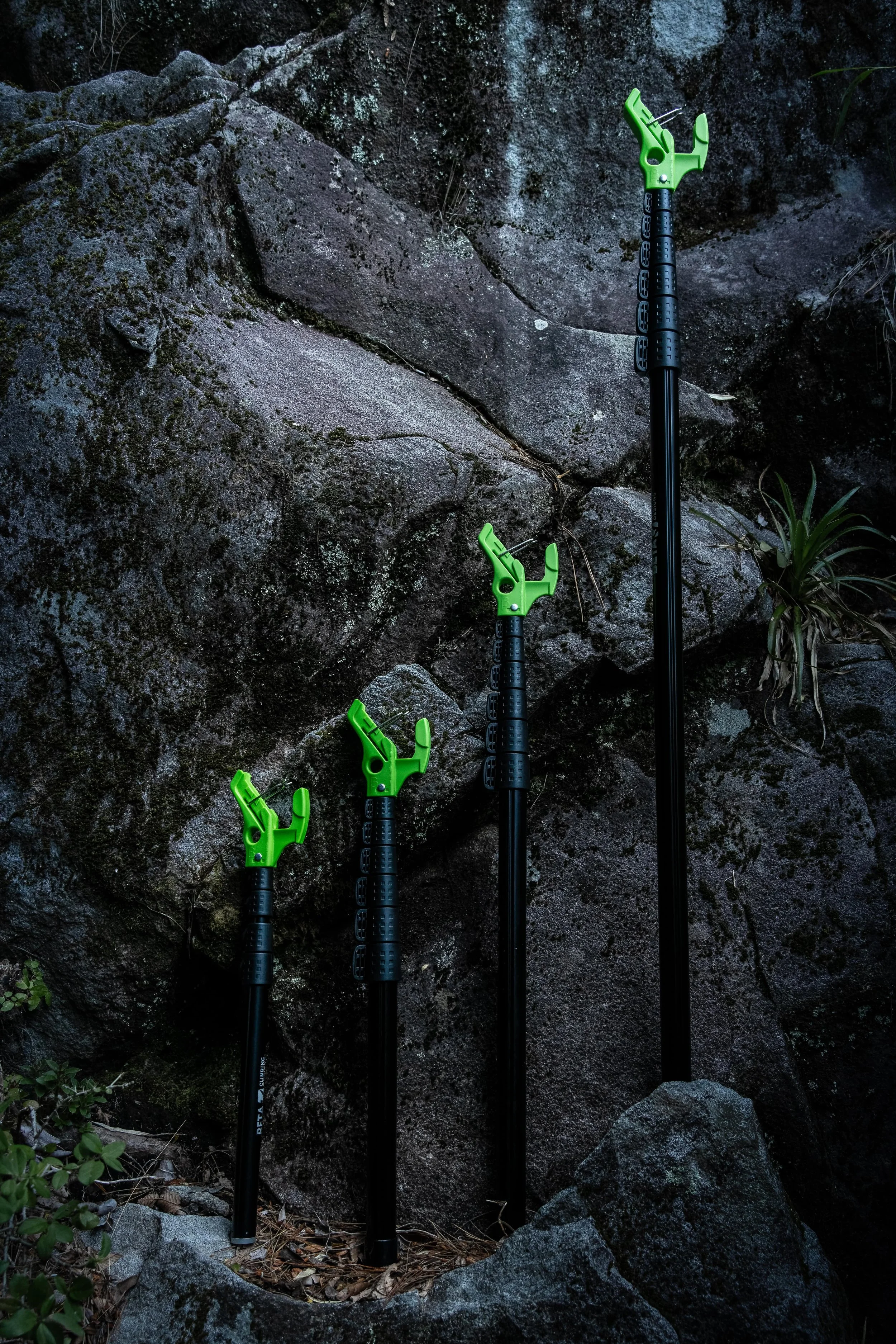The range of 4 Betastick Evo Clipsticks for sport climbing are shown vertically against a rock.  The range is Betastick Evo Climb, Betastick Evo Compact., Betastick Evo Superstandard, Betastick Evo Ultra Long