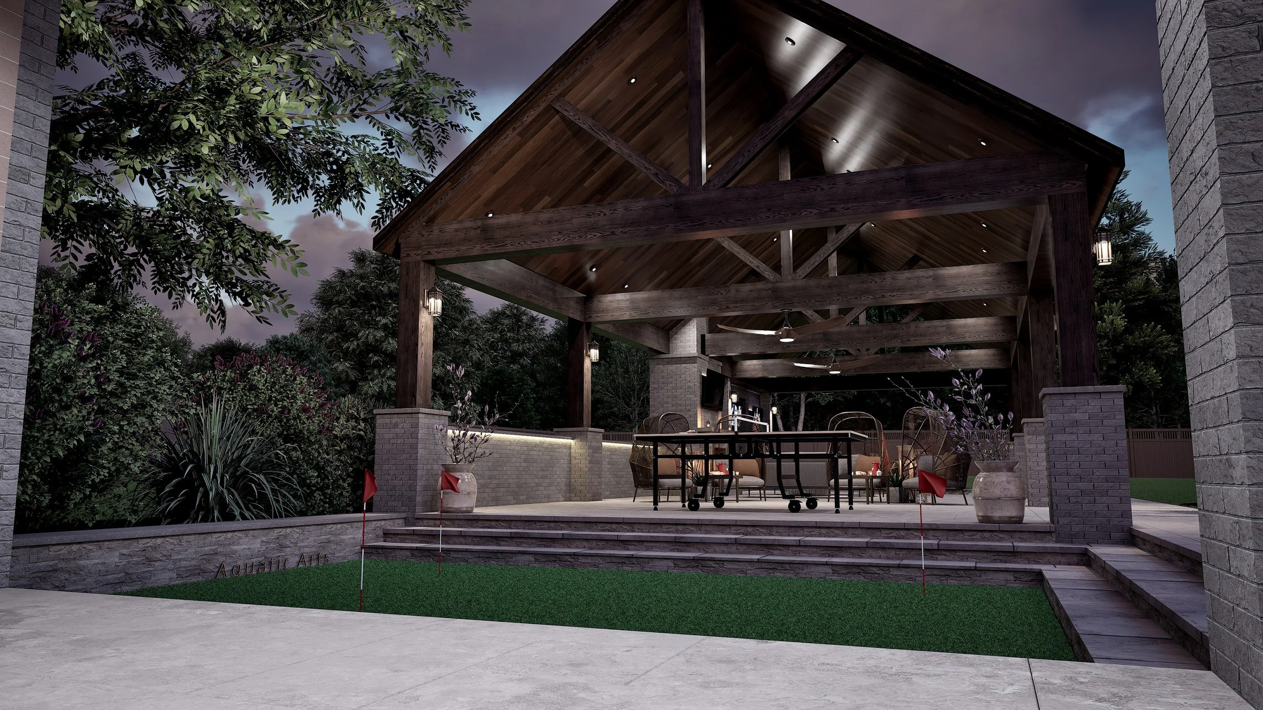 Night view of an outdoor covered patio with wooden beams, ceiling fans, and comfortable seating, surrounded by greenery and stone accents.