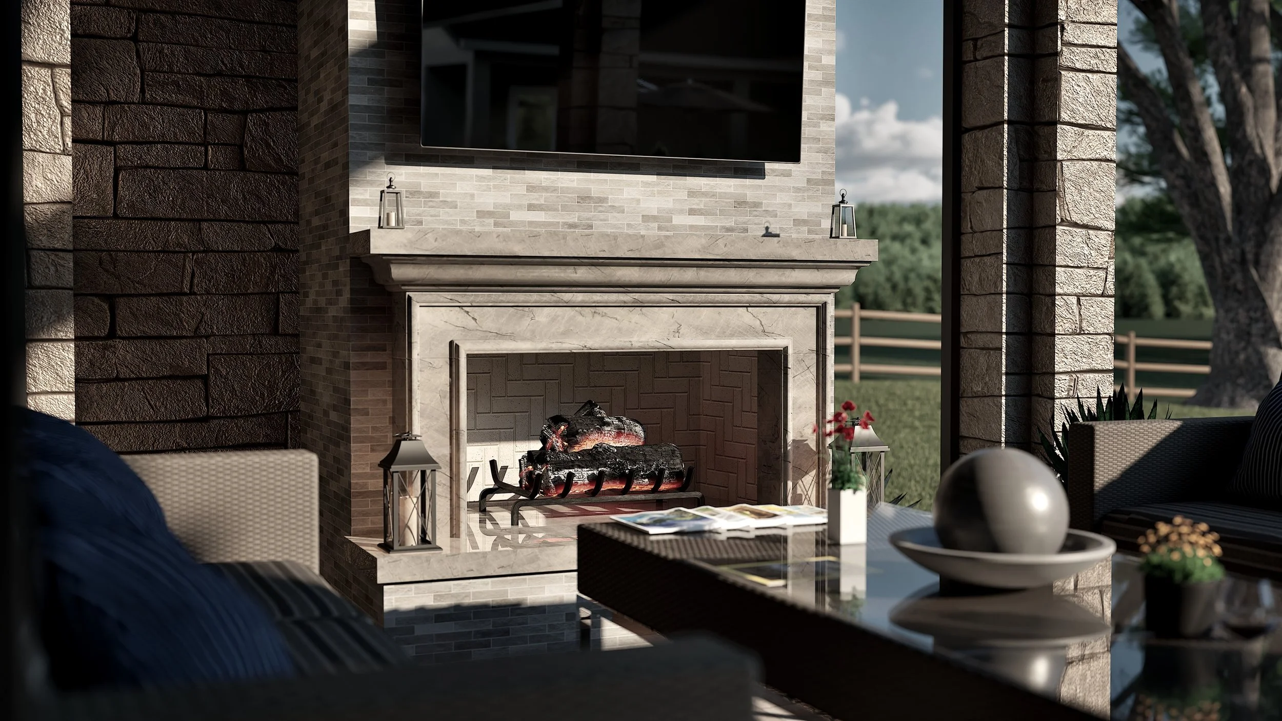 Outdoor living space featuring a stone fireplace with a mounted television above, decorative lanterns on the mantel, and patio furniture including a table with a bowl, a sphere, and potted plants. In the background, a grassy yard with trees and a wooden fence is visible.