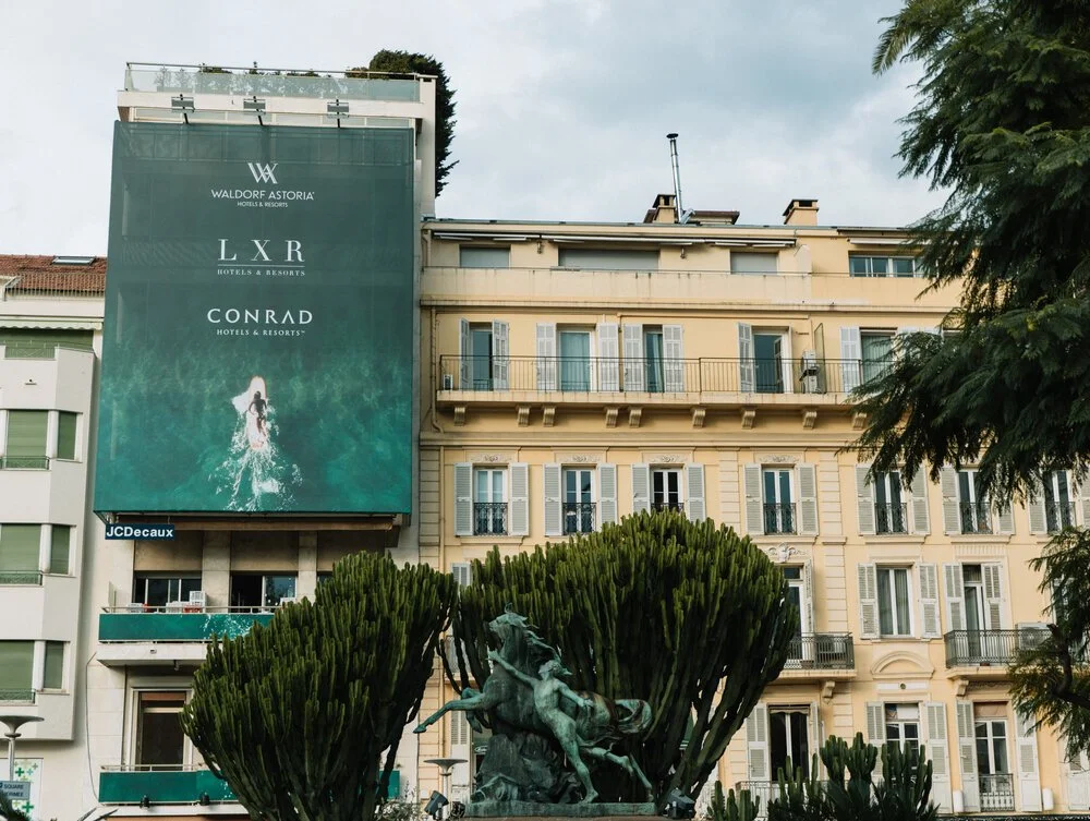 Hilton luxury brands OOH building signage at ILTM Cannes — LXR Conrad  Waldorf Astoria exterior advertising designed by Tiny Penthouse Studio