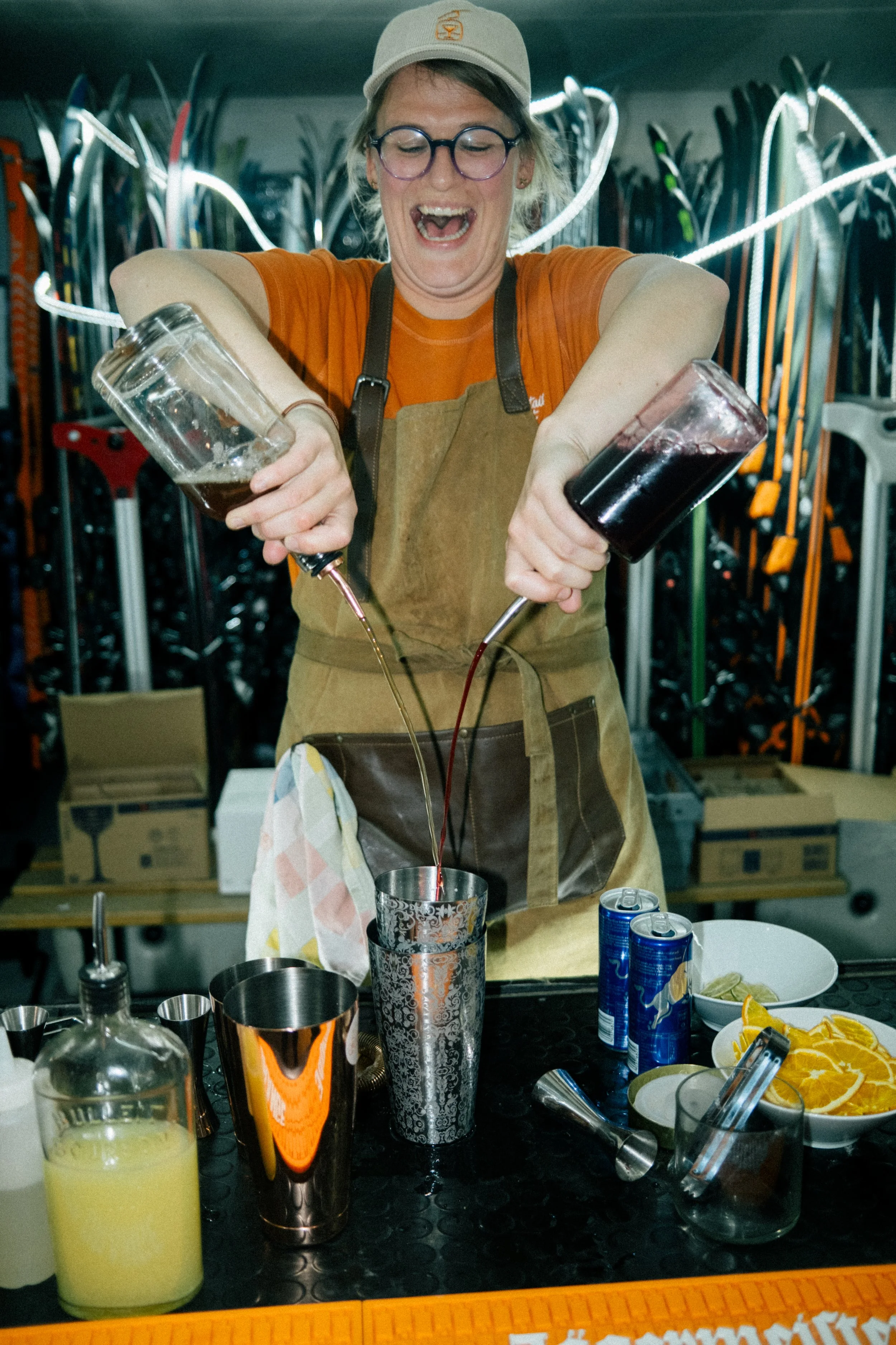 bartender pooring from 2 bottles and creating a mocktail cocktail, in a ski store
