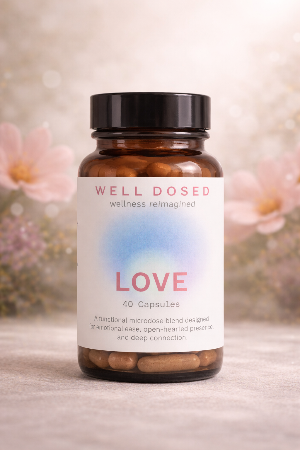 A bottle of wellness capsules labeled "LOVE" with a white label, pink and blue design, and background of pink flowers and soft bokeh lights.