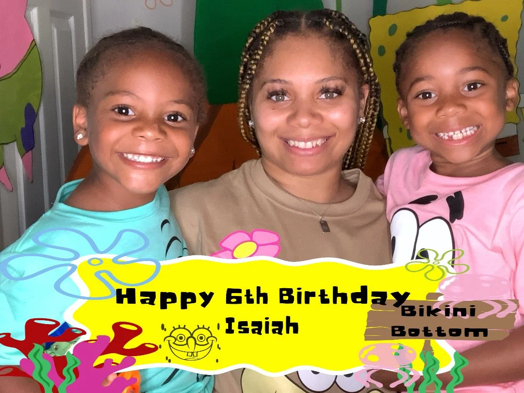 Three smiling people, an adult woman and two young children, celebrating on a colorful backdrop with a birthday sign that reads "Happy 6th Birthday Isaiah," decorated with cartoon flowers and tropical designs.