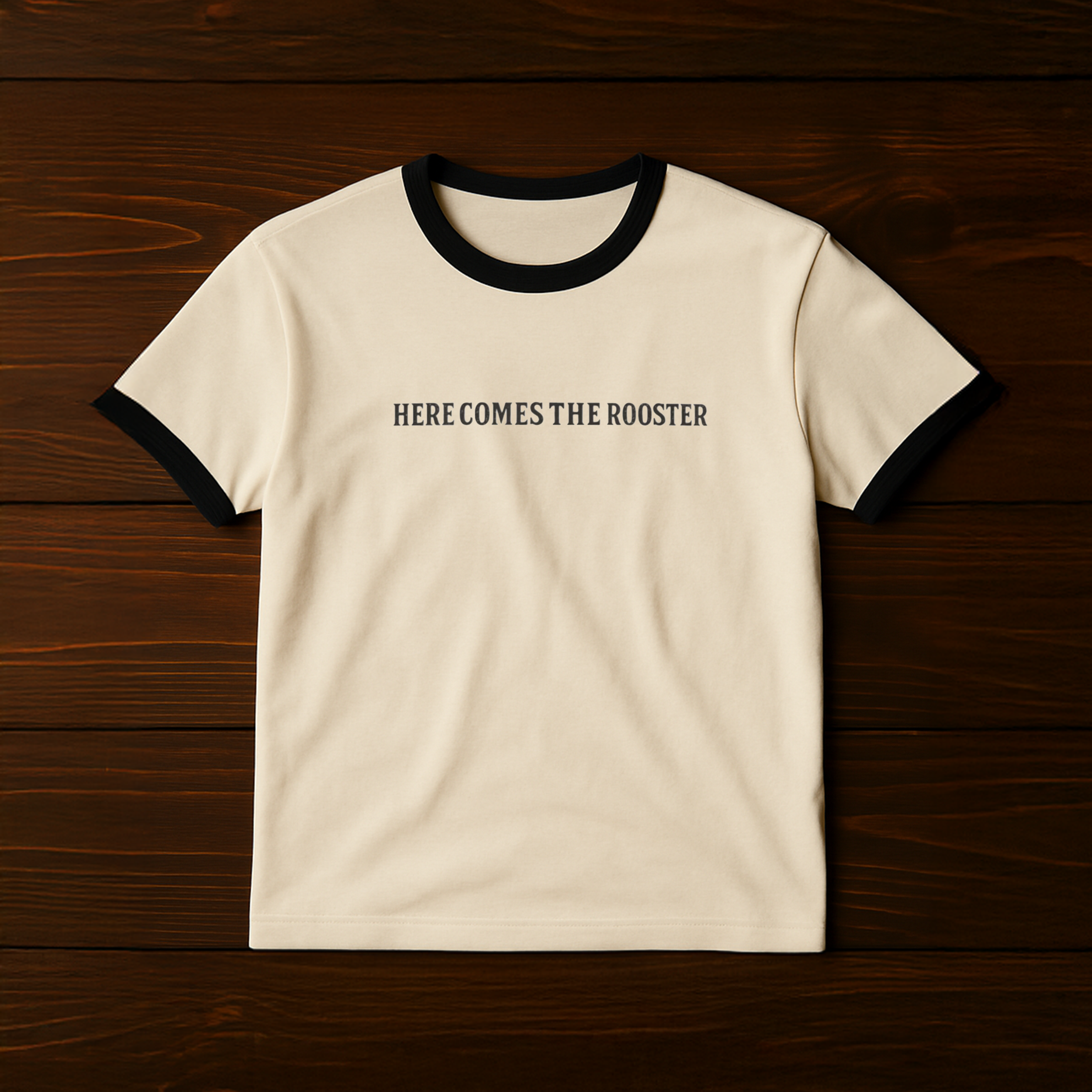Here Comes the Rooster Ringer Tee in cream with black collar and sleeves, front text reads Here Comes the Rooster.