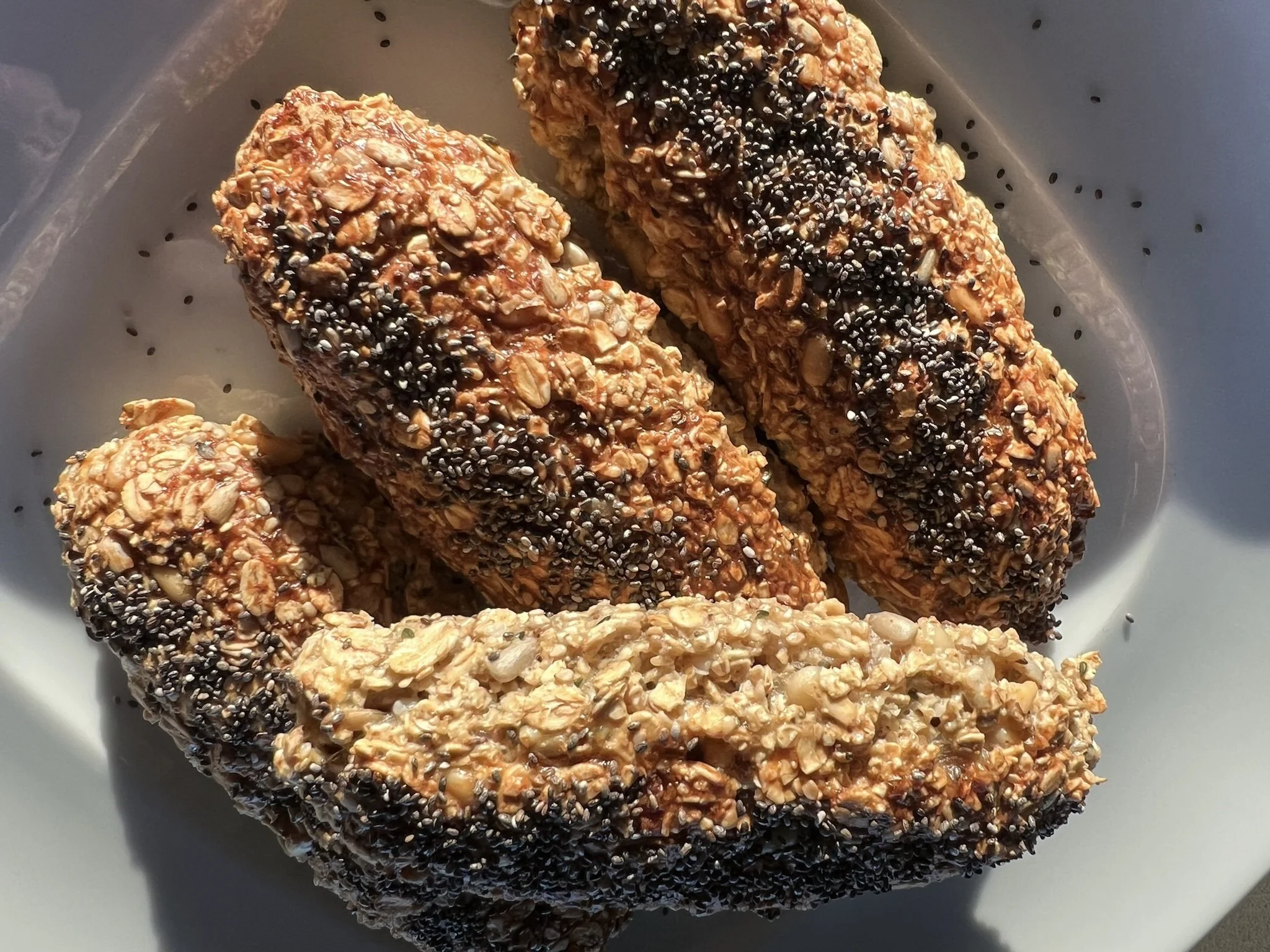Geröstete Haferflocken mit Sesam und schwarzem Sesam, in einer weißen Schale