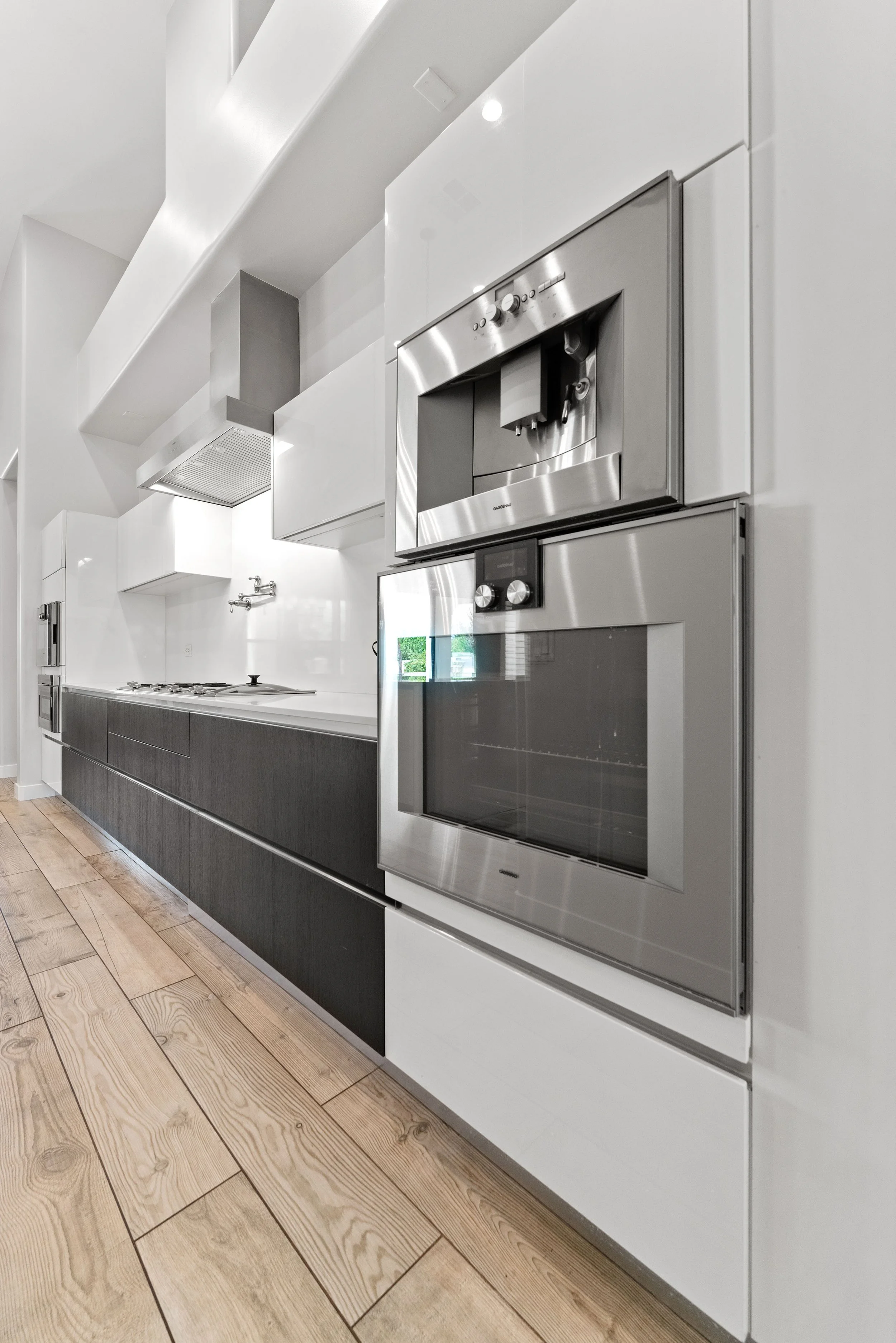 vertical kitchen shot white countertops black cabintets gourmet oven with built in coffee maker beautiful real estate images