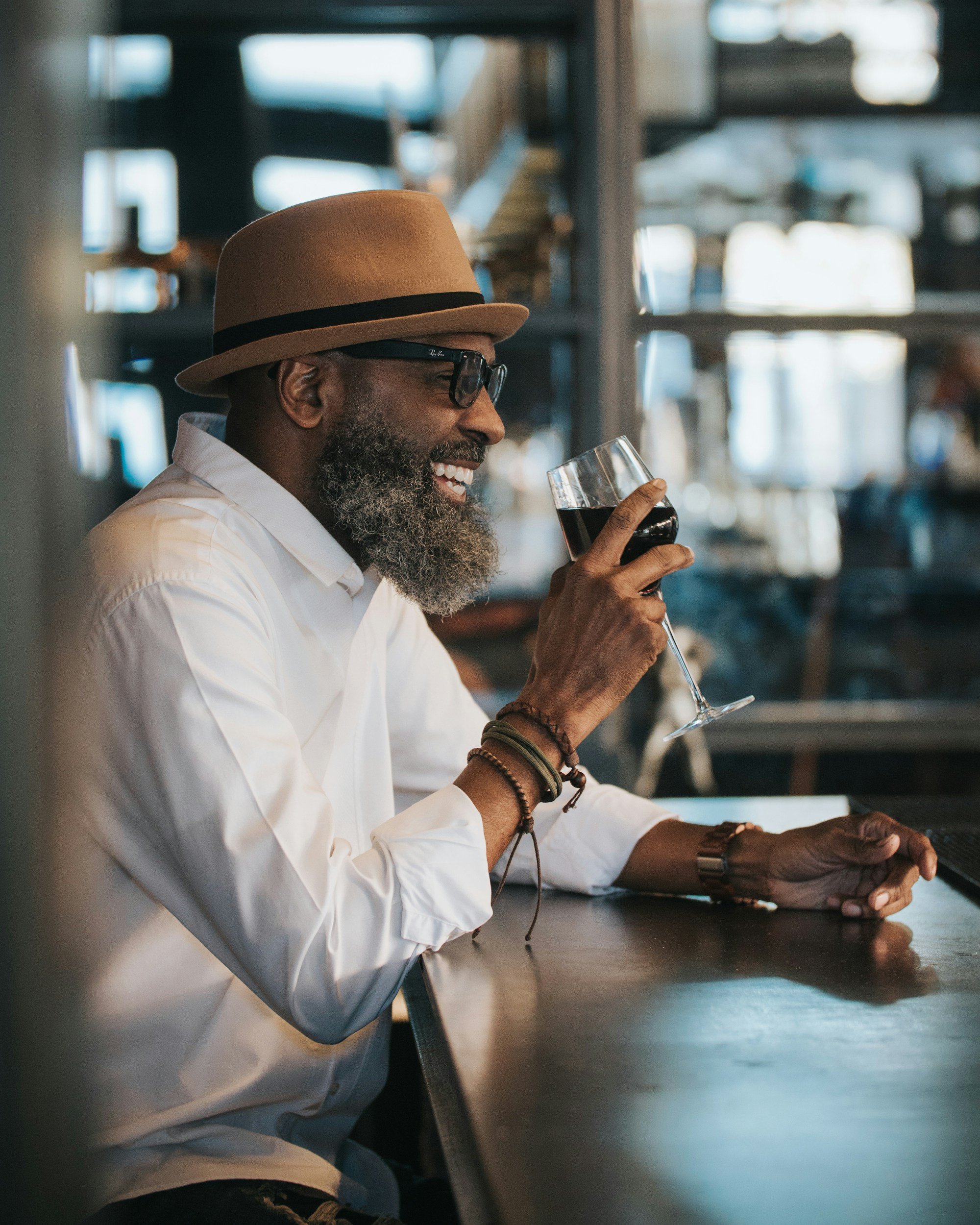 A man celebrating with a glass of red wine after closing a real estate deal symbolizes success. In real estate, client achievements, success stories. trust