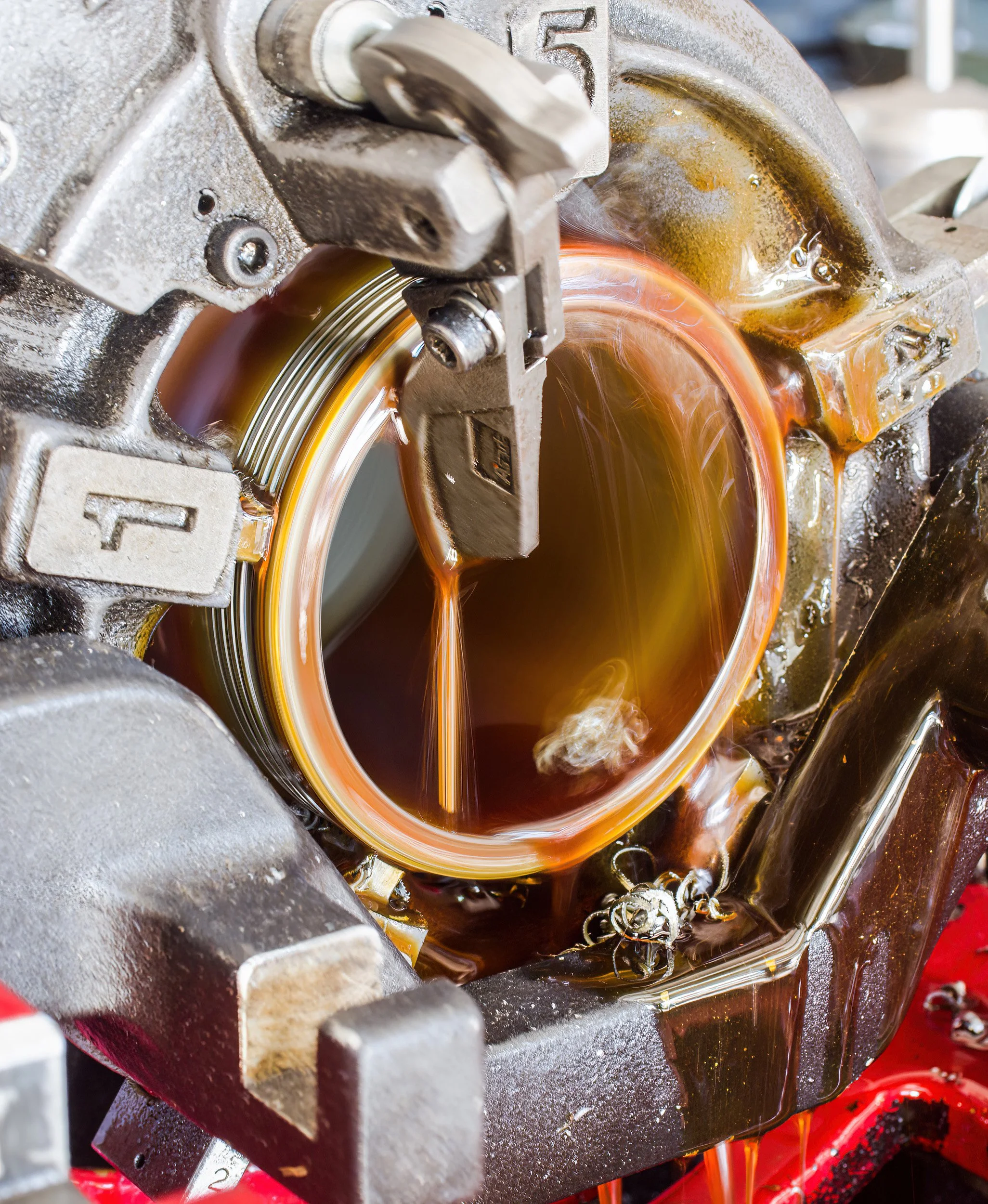 Close-up of a metalworking machine pouring molten metal into a mold.