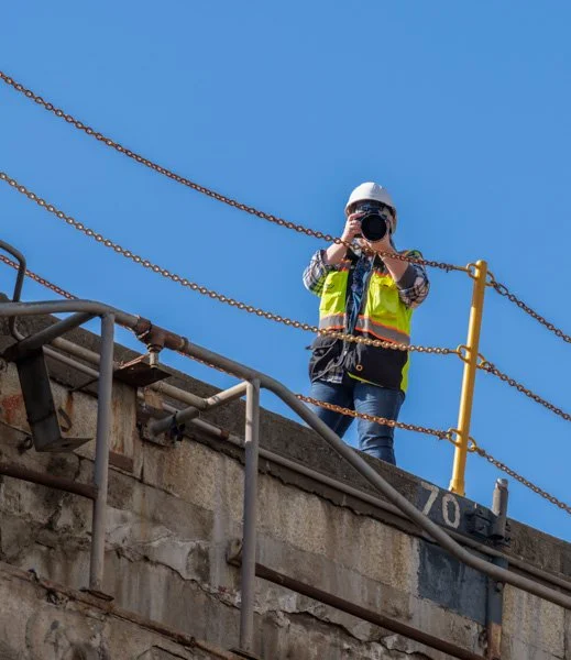 Aimee shooting with a long lens at an industrial ship yard