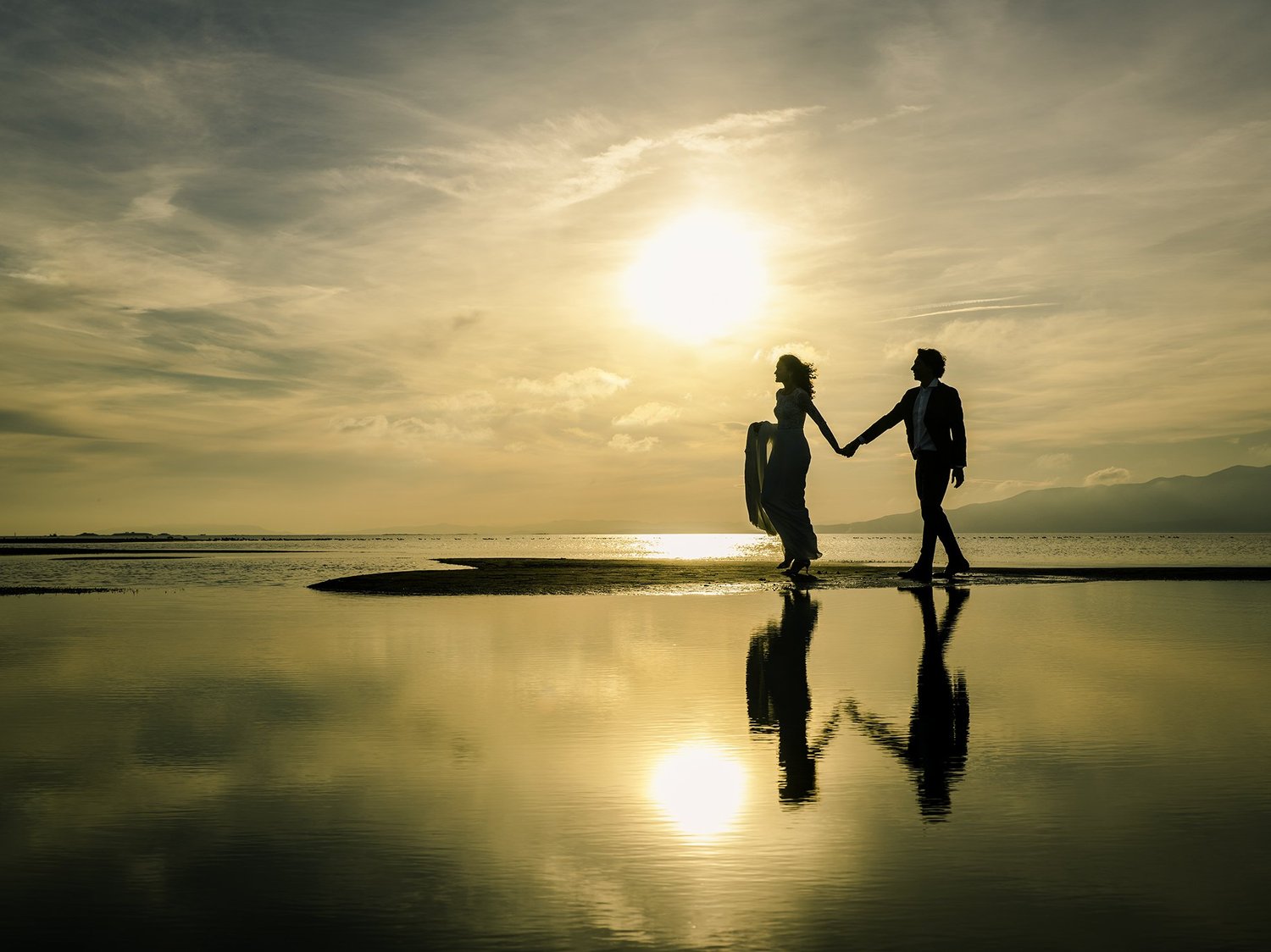 A newlywed couple by the water during golden hour