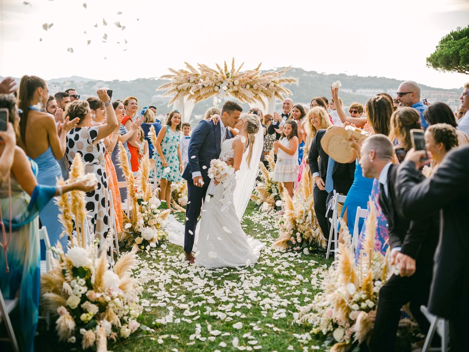 Newlyweds leaving their ceremony surrounded by confetti and friends