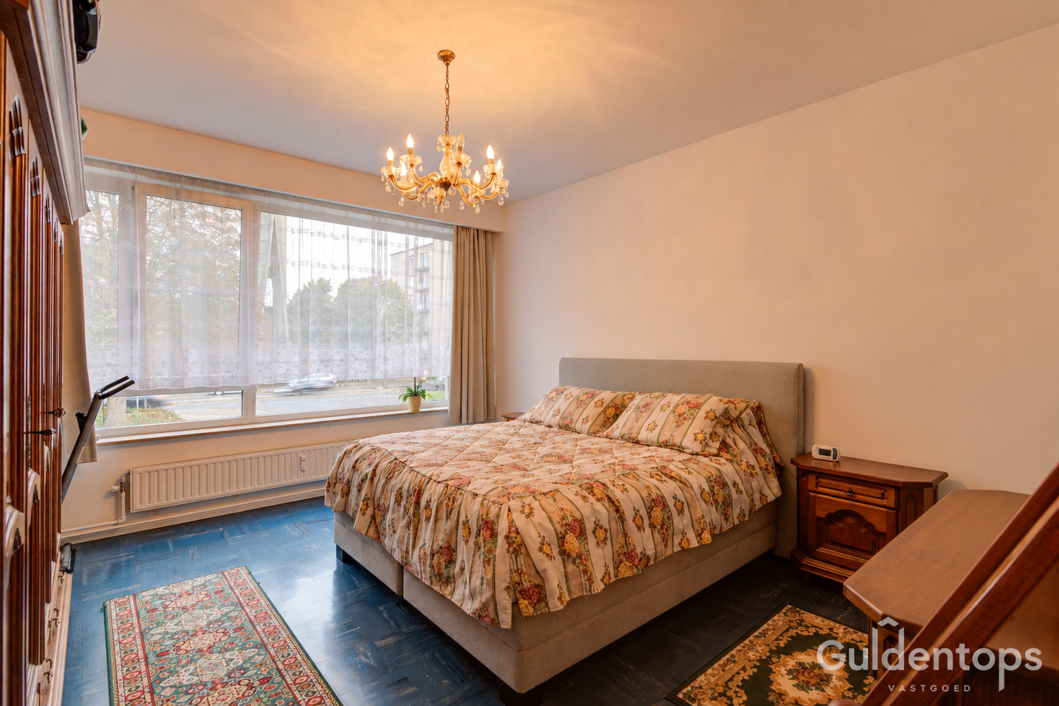 Opgeruimde slaapkamer met bloemrijke bedsprei-2.png