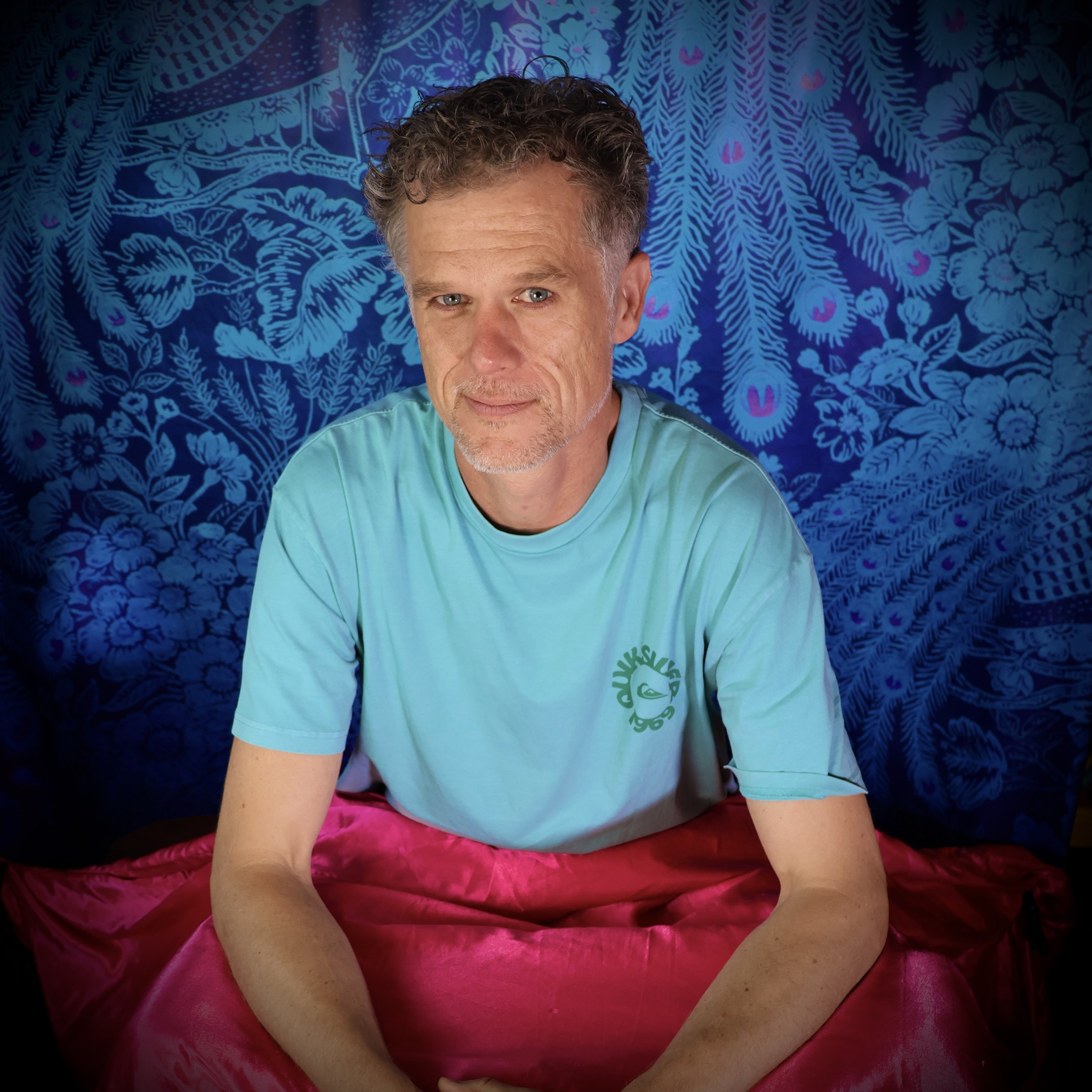 Blauw t-shirt met groen logo, grijs krullend haar