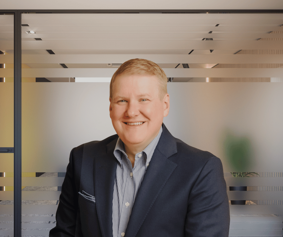 Smiling man in business suit in modern office setting.