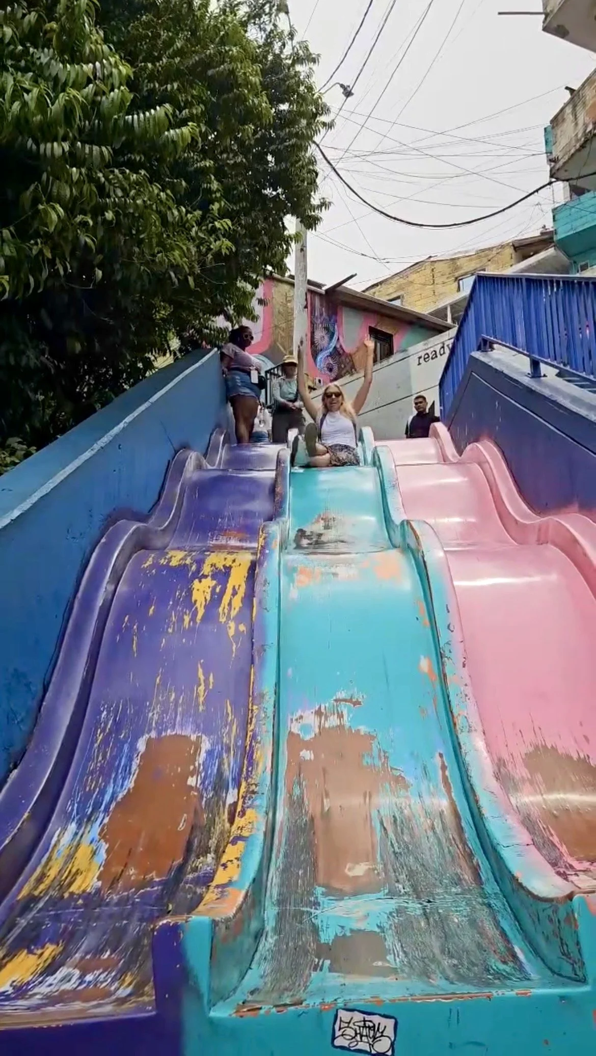 Woman going down slide in Comuna 13, Medellín, Colombia