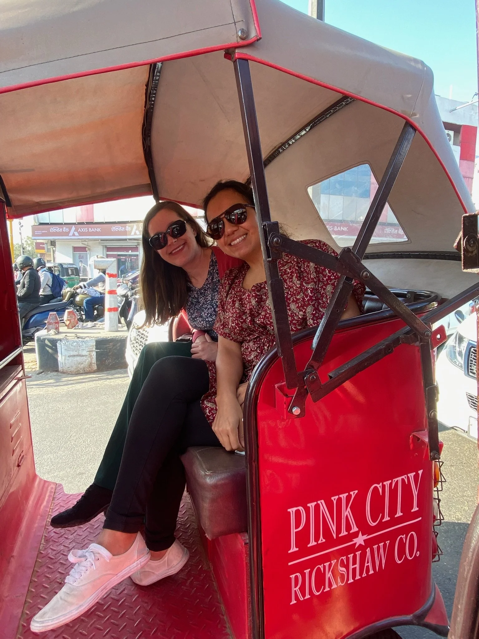 Two women in the backseat of a Pink City Rickshaw