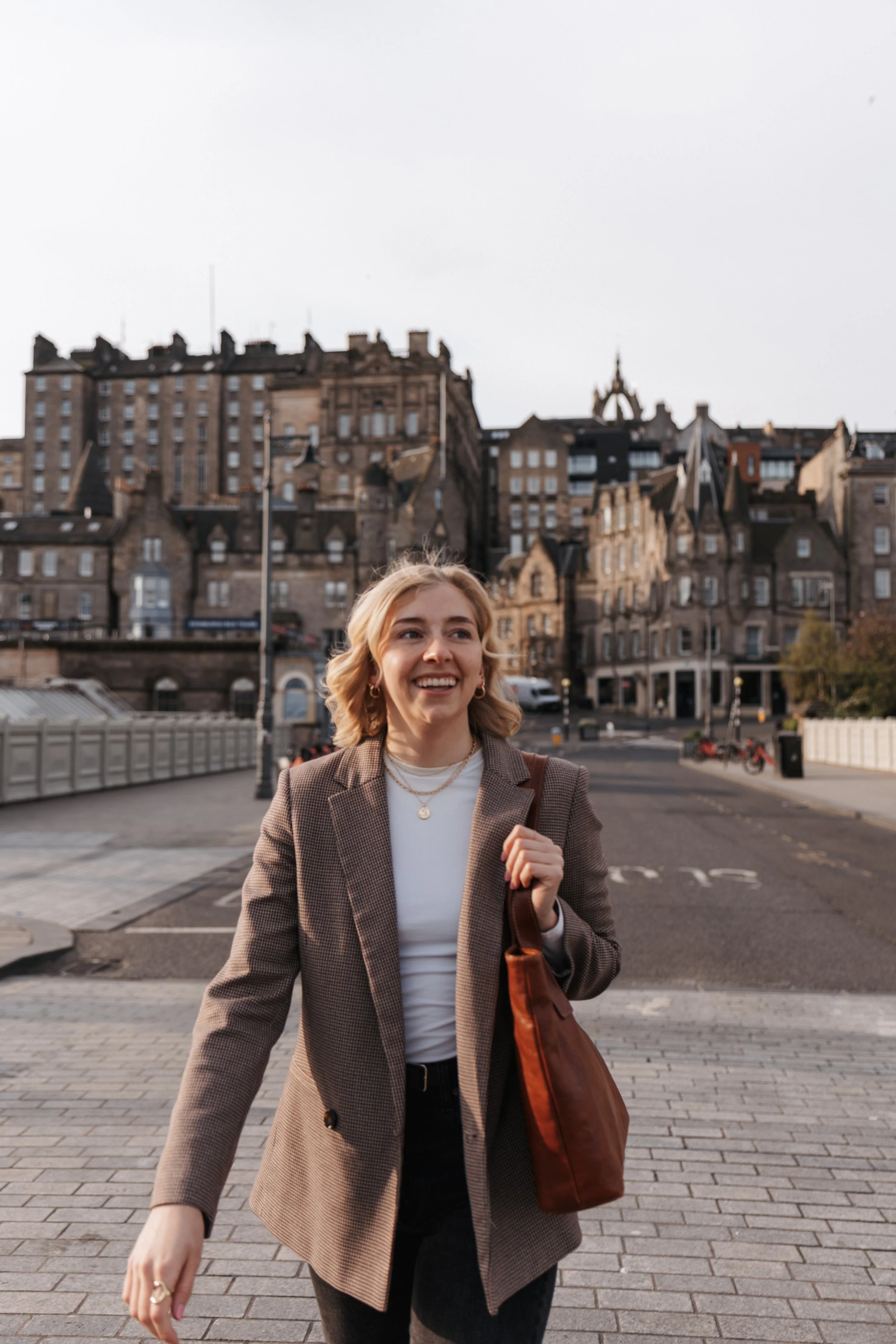 Woman walking across Waverley Bridge in Edinburgh