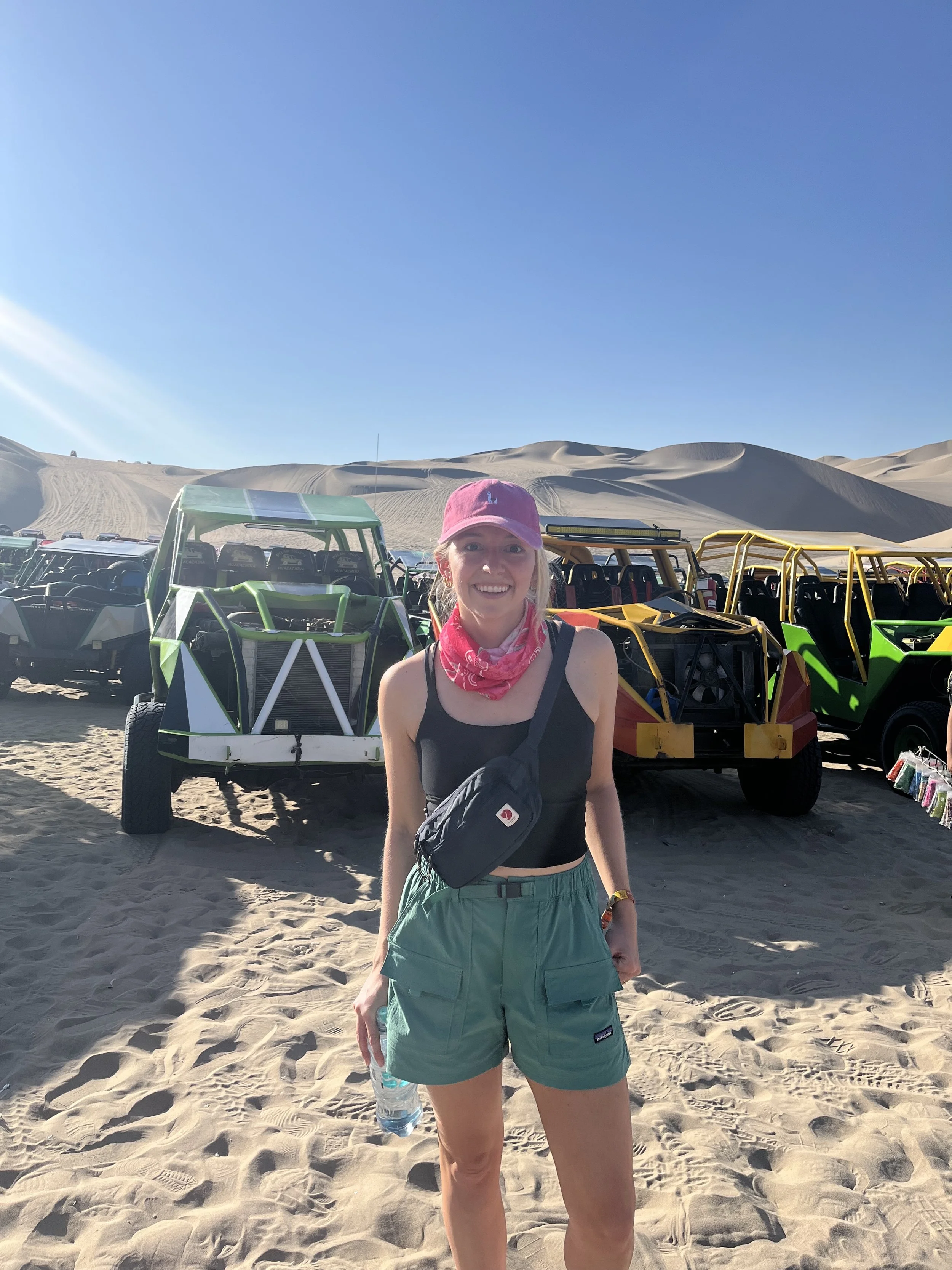 Woman standing in front of dune buggies in Huacachina, Peru