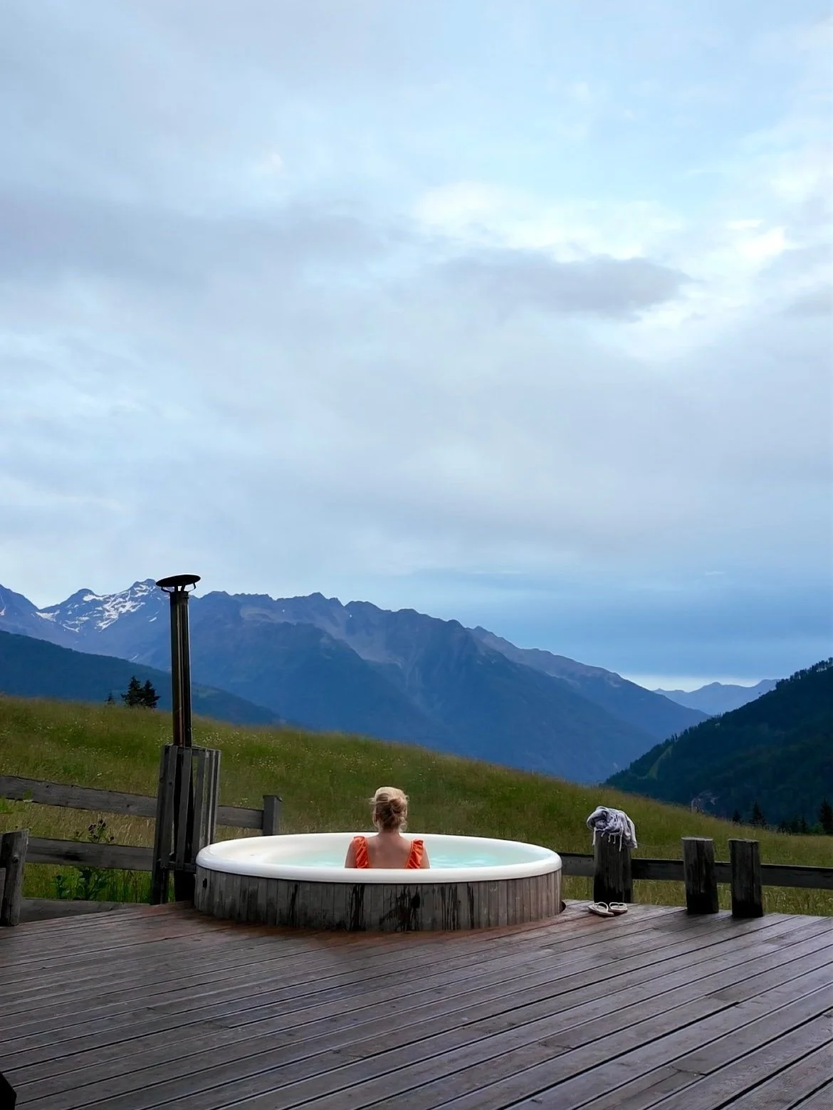 Woman in hot tub with mountains in background