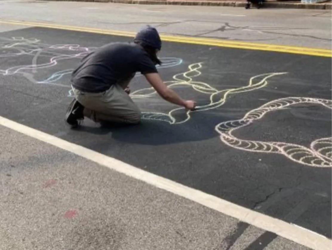 20 ft. "Daniel Prude" chalk memorial created during a Rochester Black Lives Matter protest, honoring a black man in the community lost to brutal police violence. This street artwork served as both a public act of mourning and a call for justice, tran