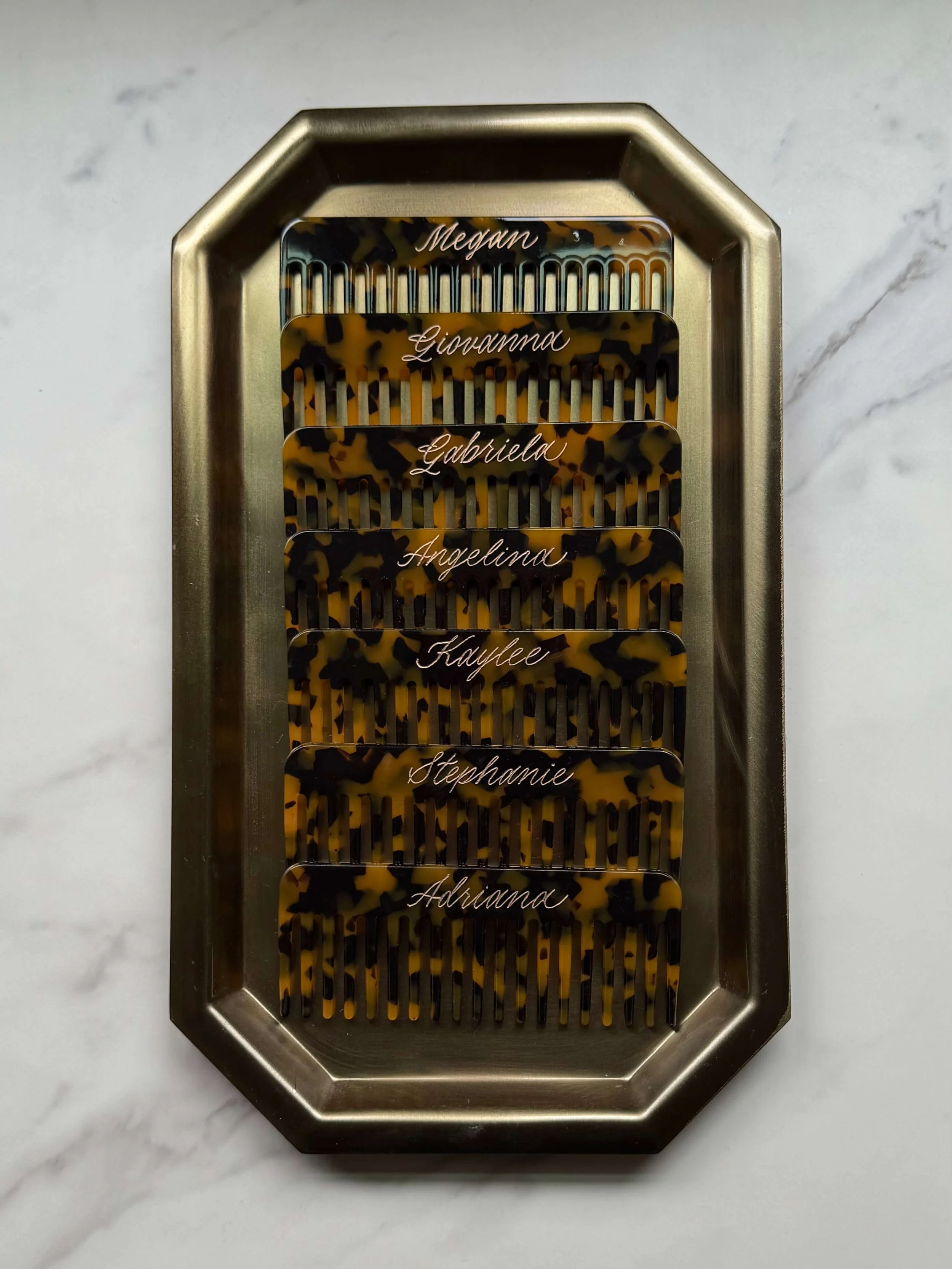  Tray of engraved tortoiseshell combs personalized with bridal party names for a wedding or event.   