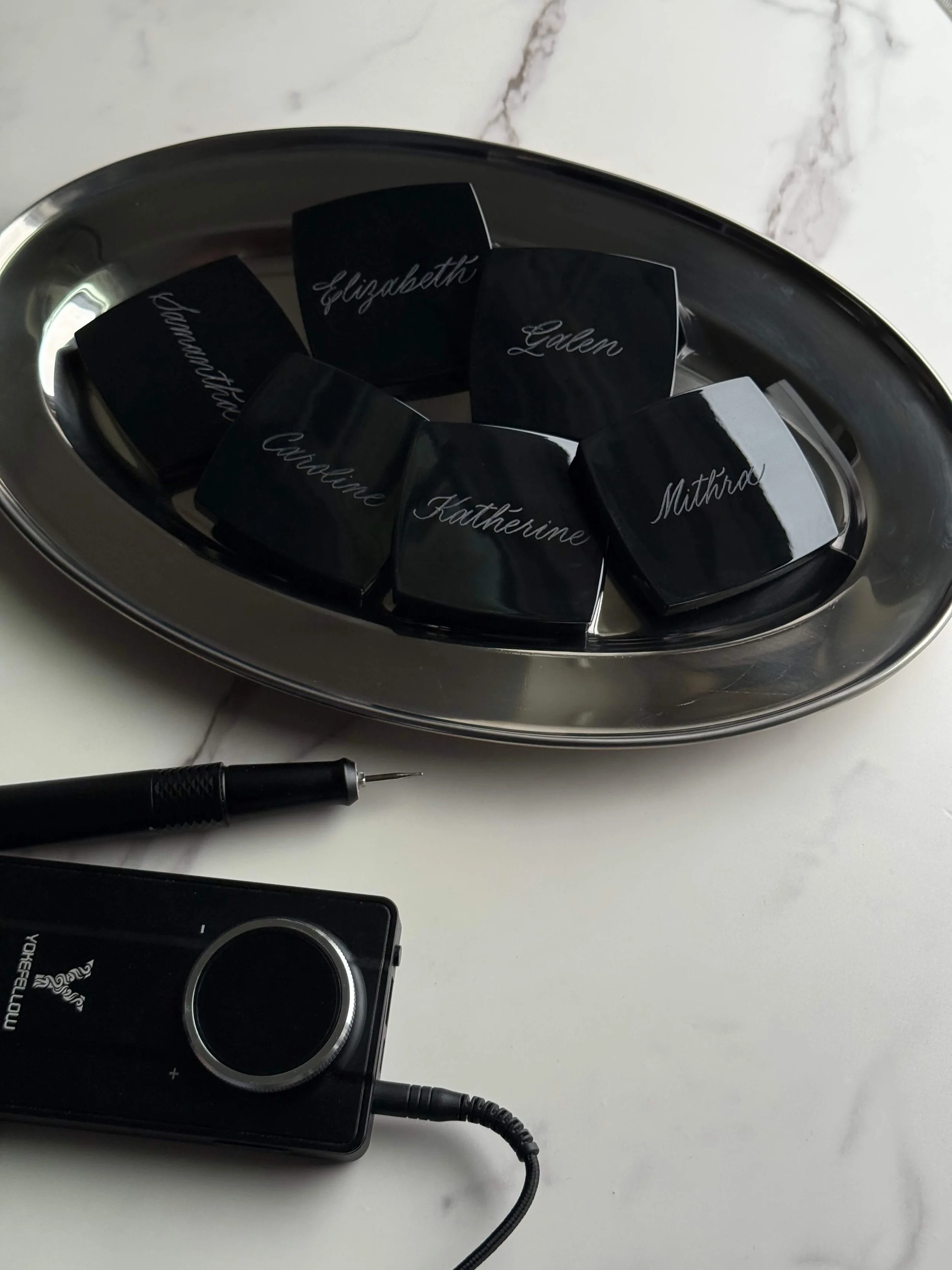 Custom black compact mirrors personalized with hand-engraved calligraphy.
