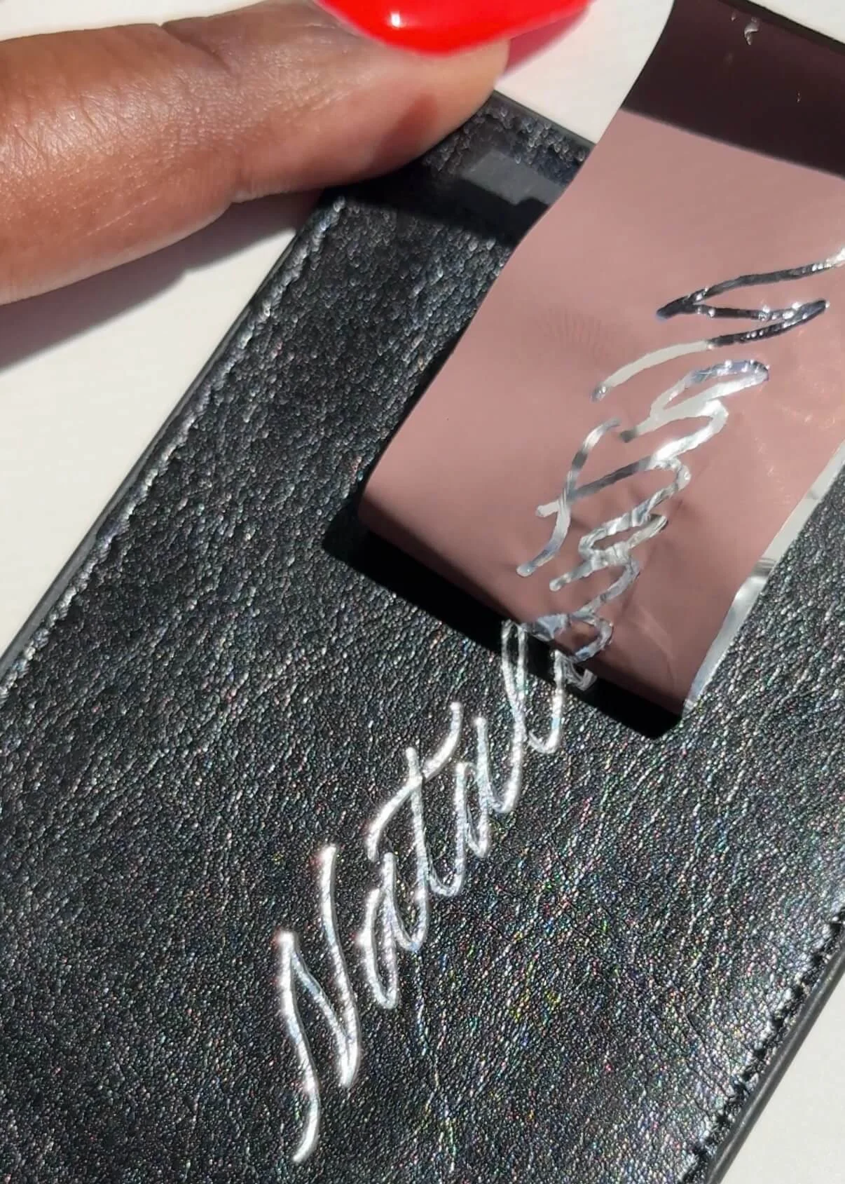 Hand-lettered genuine leather luggage tag personalized with the name Natalia in silver foil.