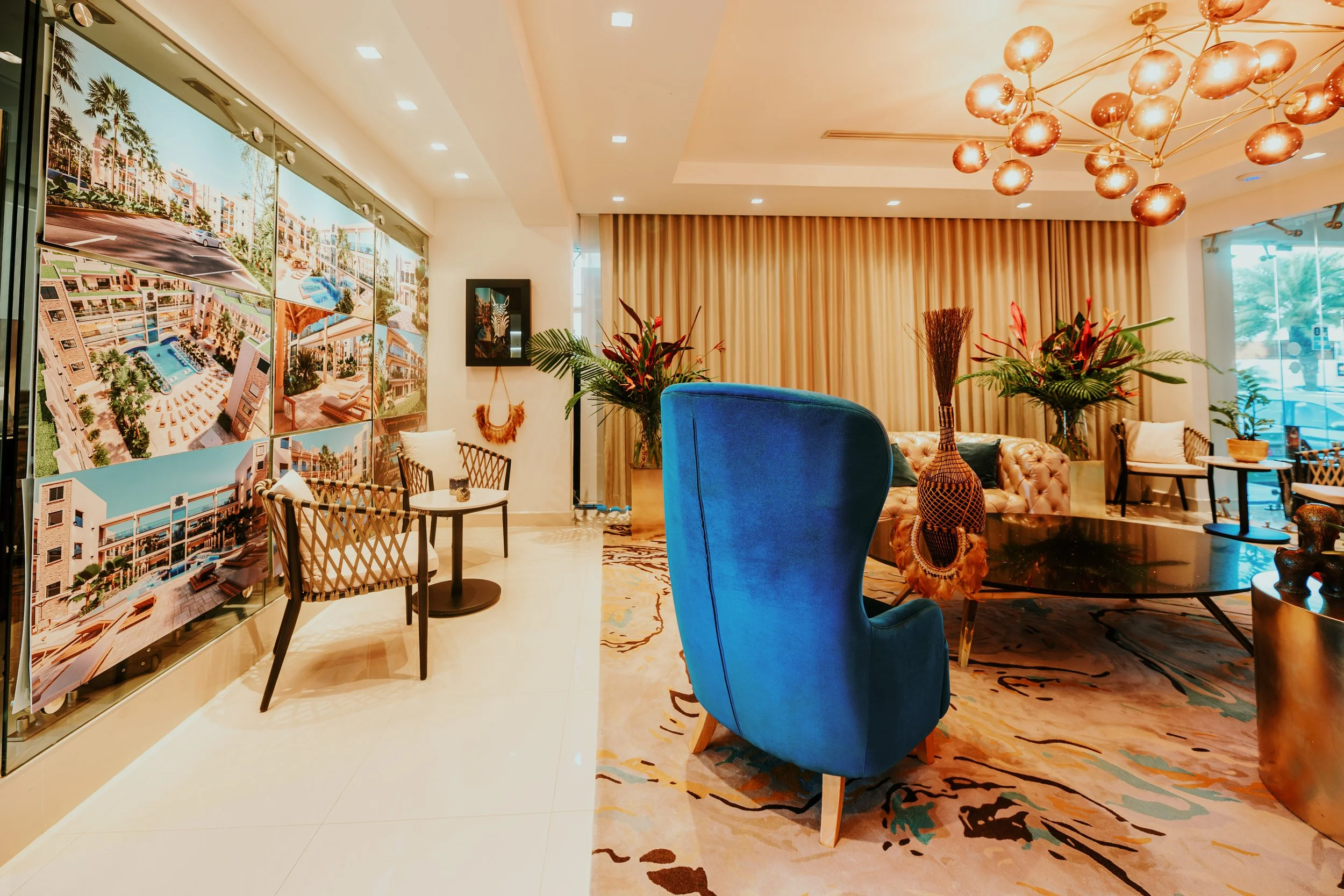 Elegant hotel lobby with colorful furniture, large wall art, and decorative plants.