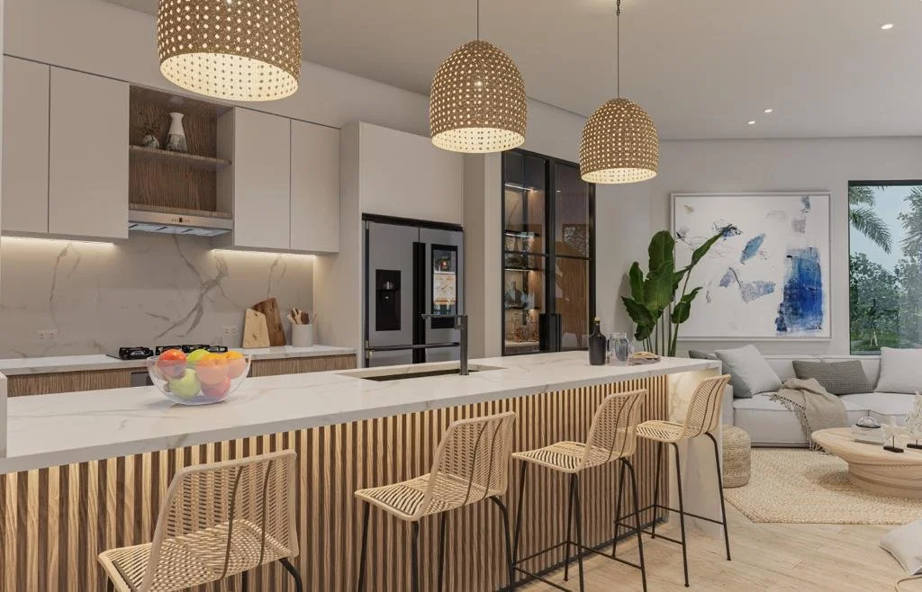 Modern kitchen with white marble countertops, wooden bar stools, three woven pendant lights, white cabinetry, and a large window with a view of greenery.