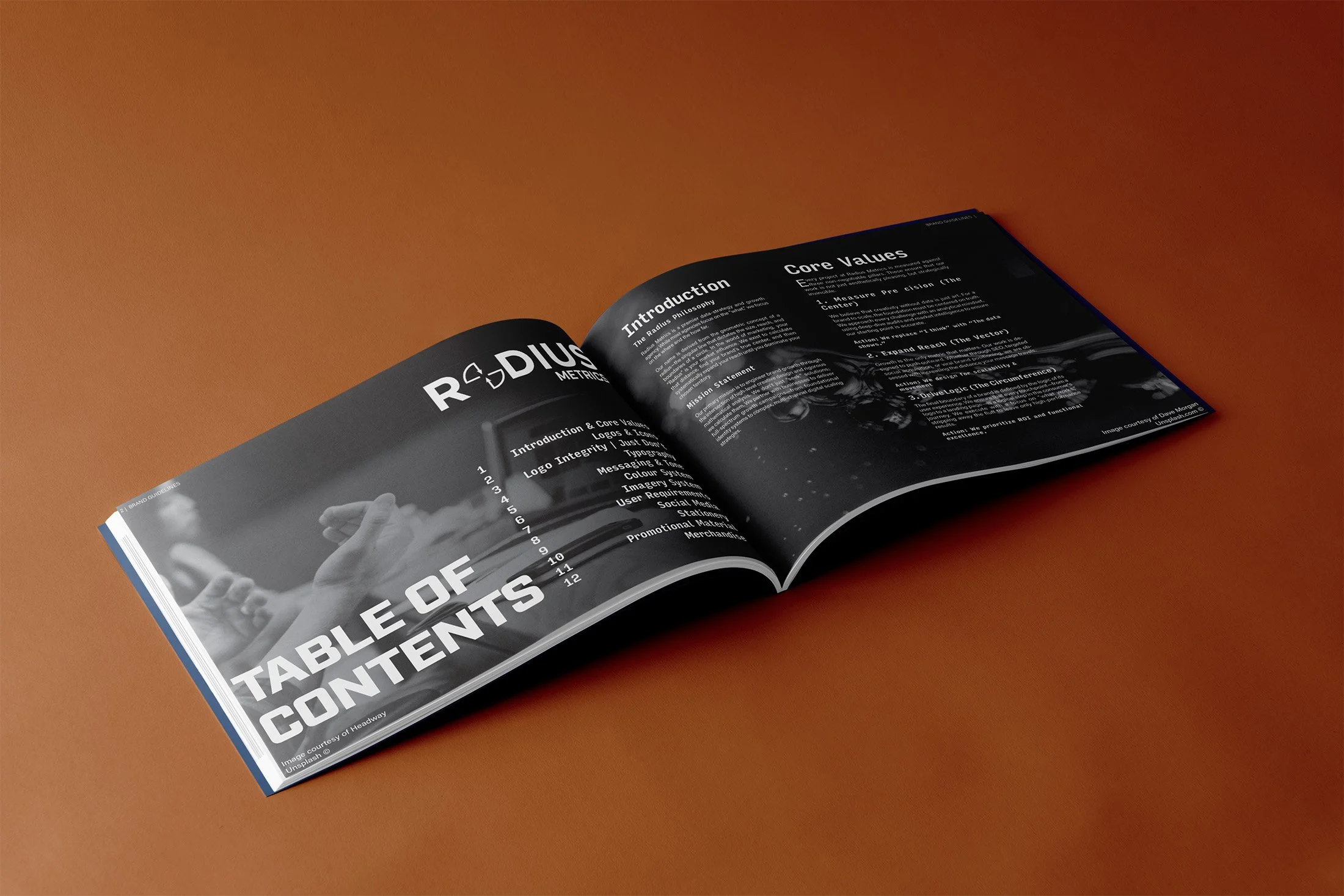 Open magazine on a brown surface showing a table of contents page and a page with an introduction and core values
