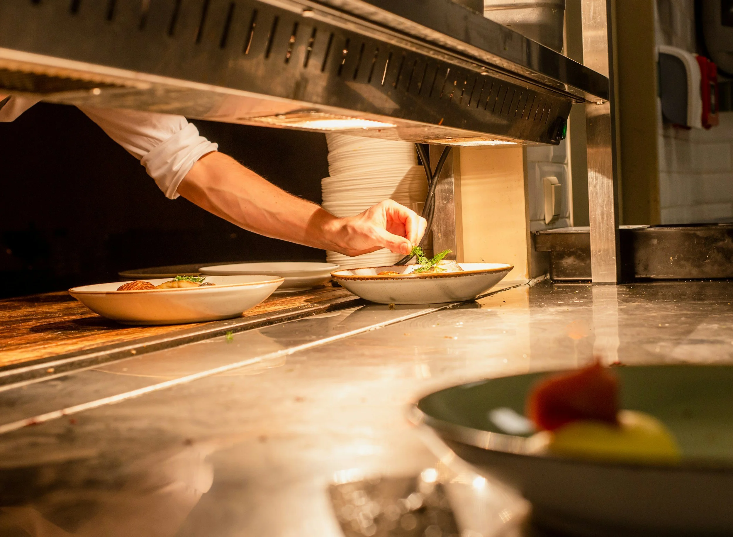 A professional chef meticulously plating a dish, representing the Mise en Place discipline applied to Shifting Focus design and photography projects.